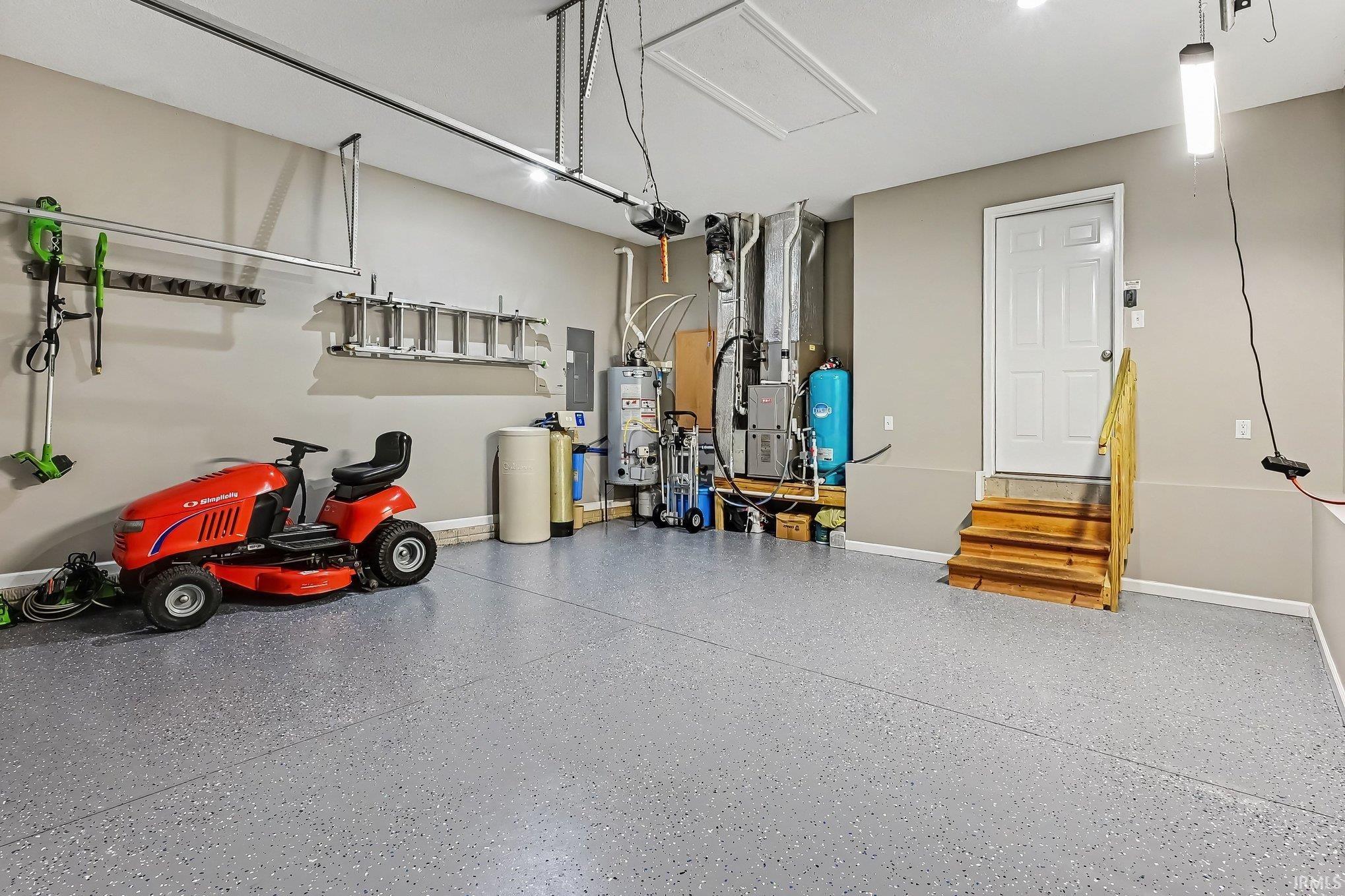 Spacious garage featuring a durable speckled epoxy floor, neutral wall tones, and recessed lighting
