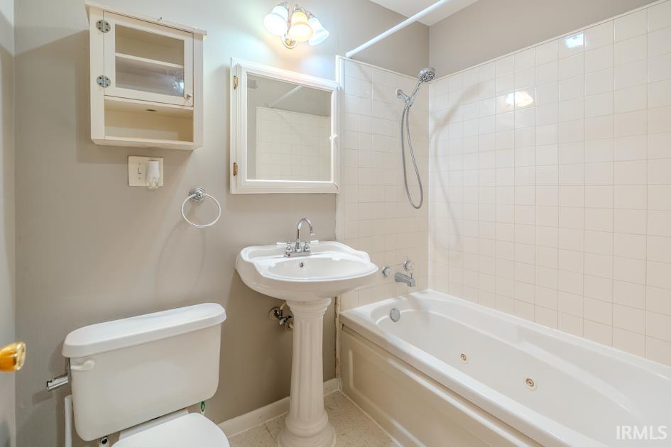 Bathroom featuring a white pedestal sink, mirrored medicine cabinet, and overhead vanity lighting