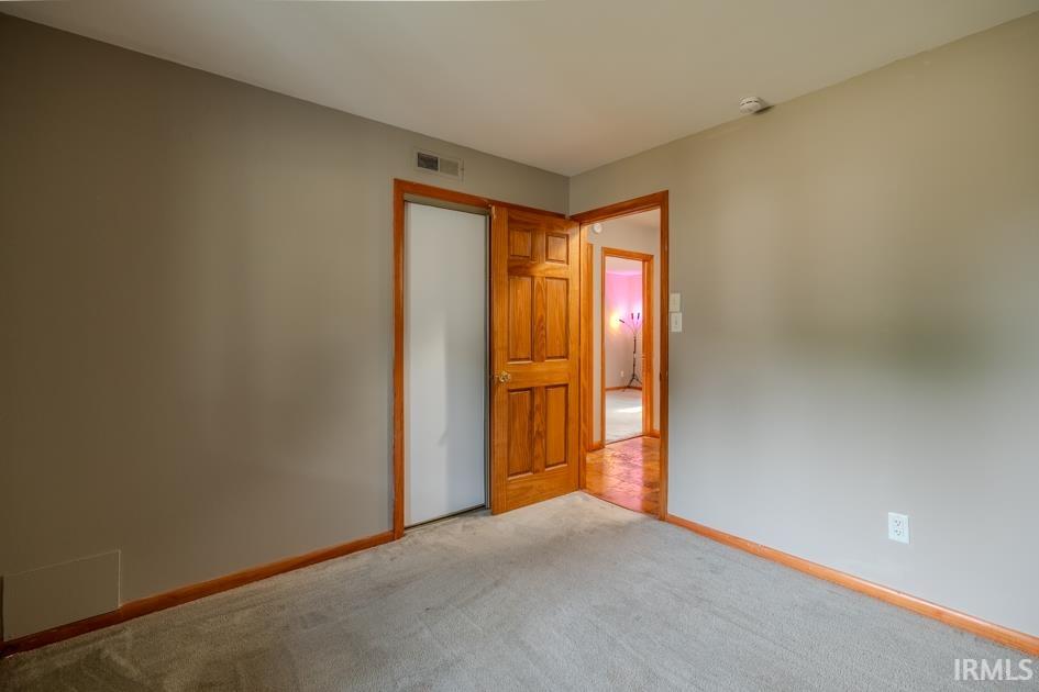 Carpeted room with a wooden door and trim