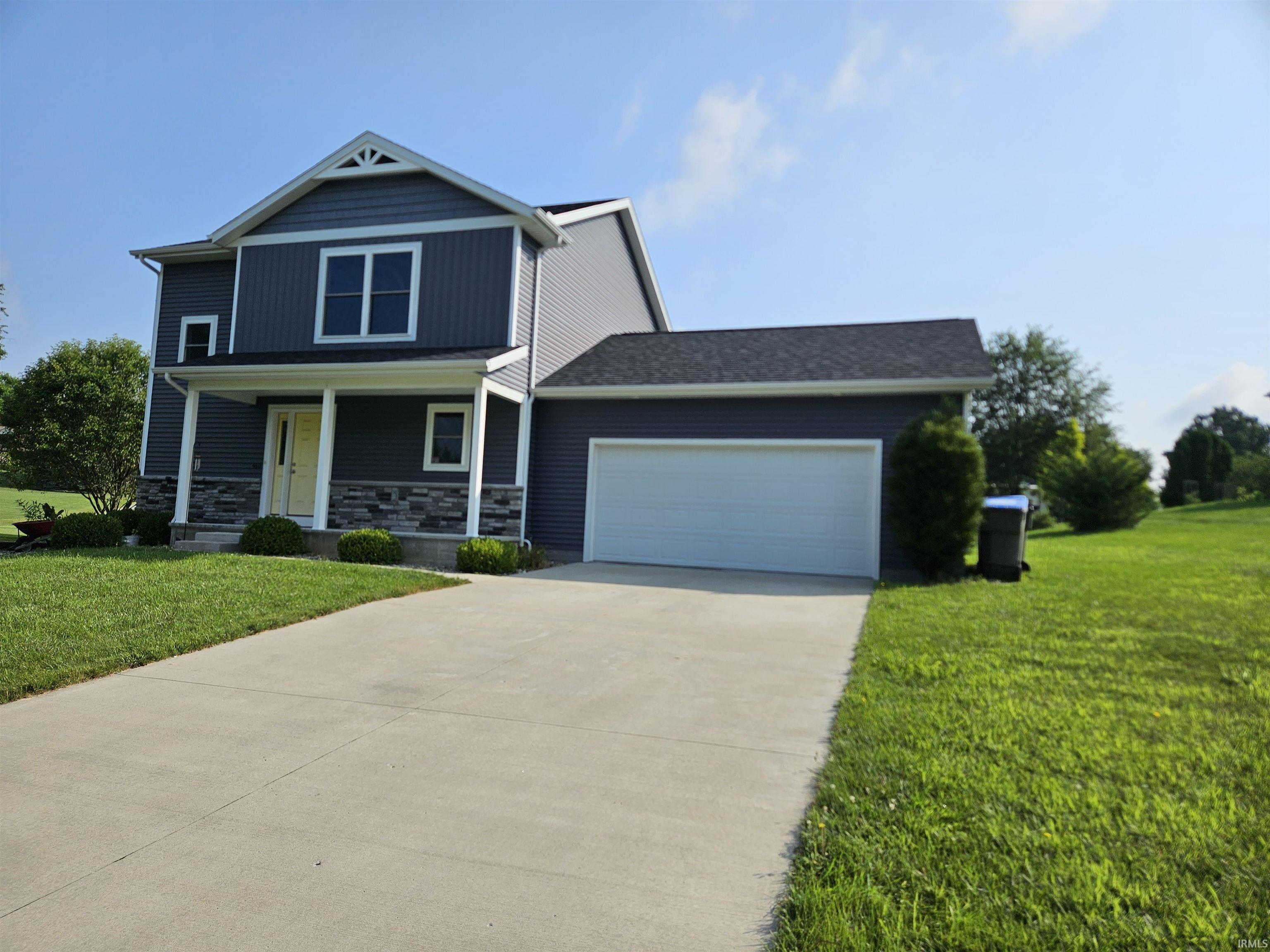 Two-story residence featuring deep blue siding and stone veneer accents