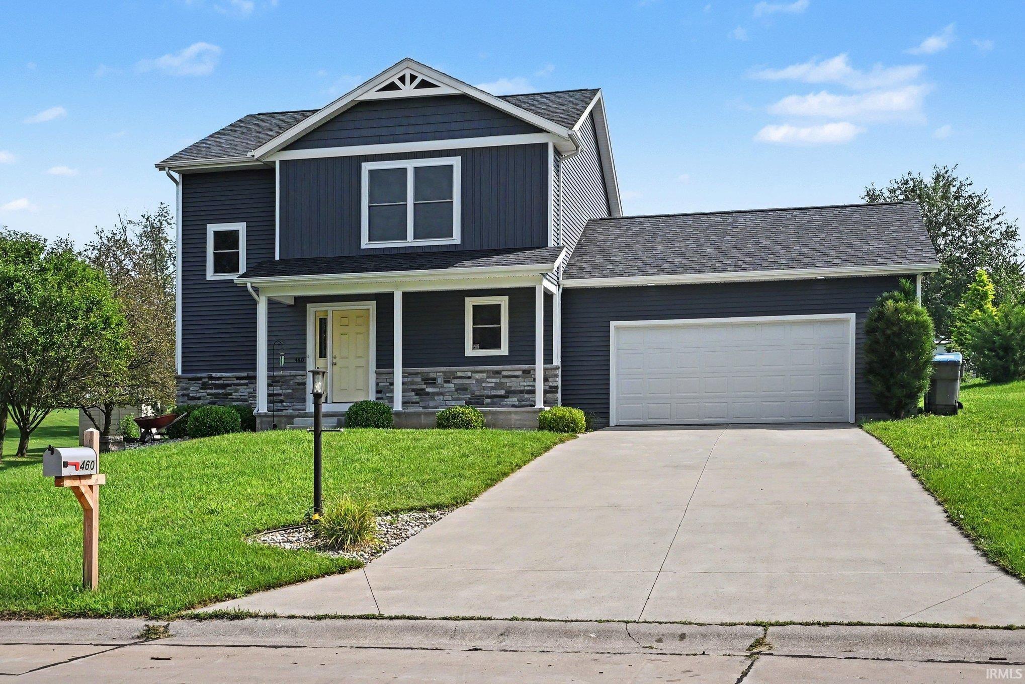 Two-story home with dark blue siding and a light yellow front door