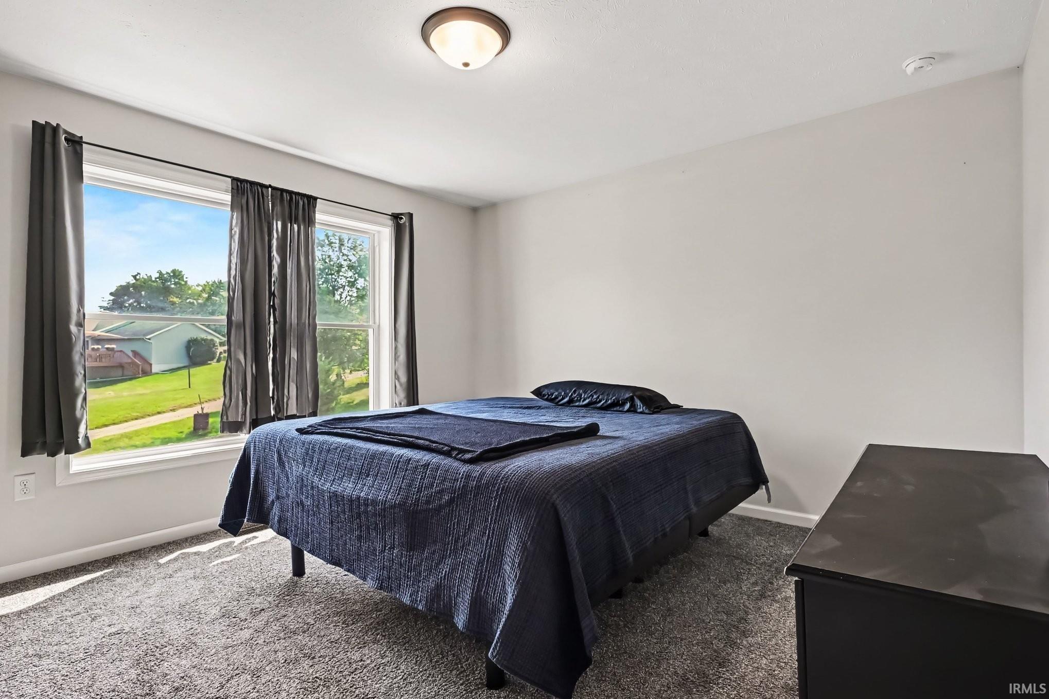 Bedroom featuring light gray walls, gray carpeting, and a flush-mount ceiling light