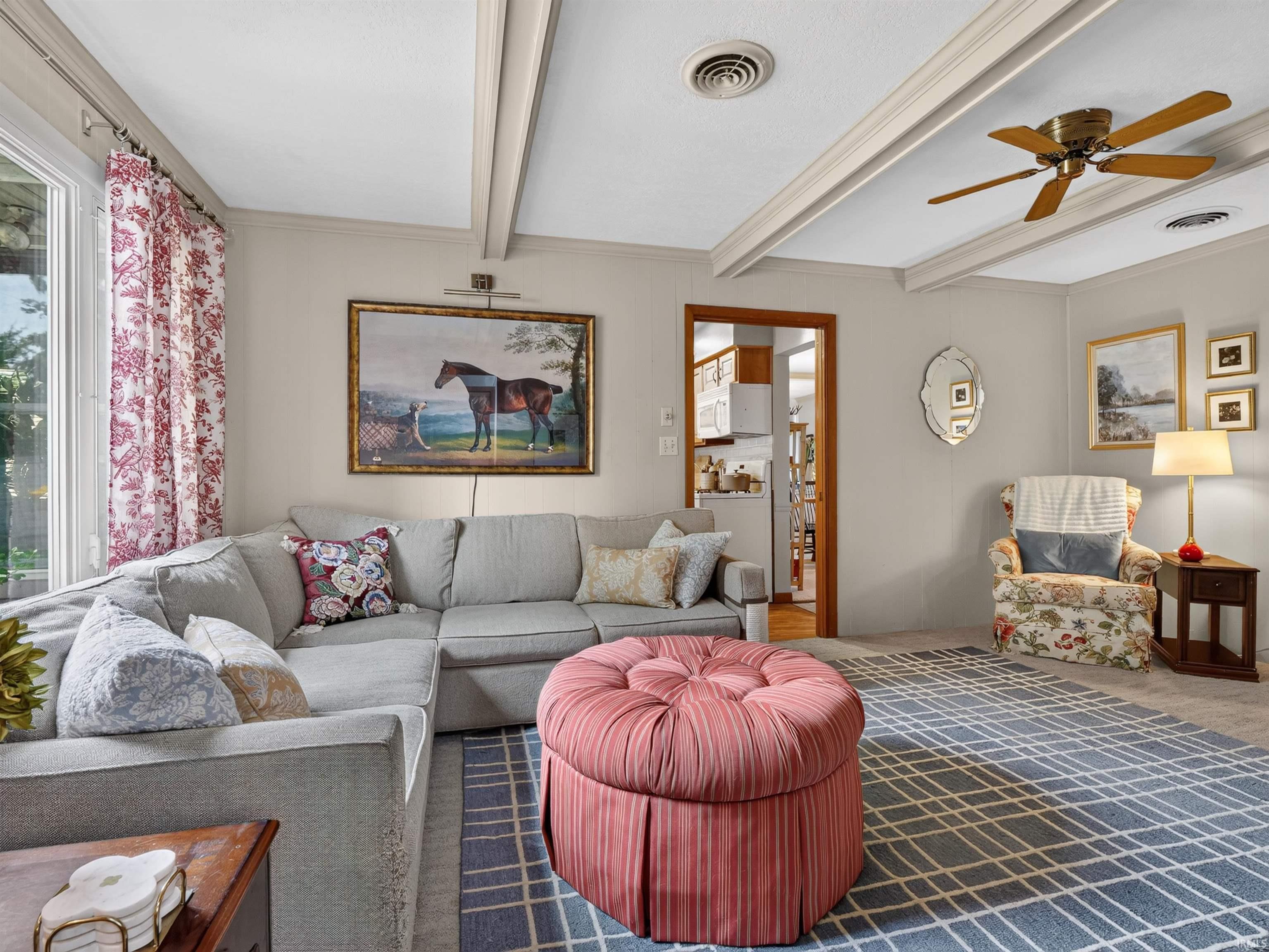 Living area featuring a ceiling fan and a large window