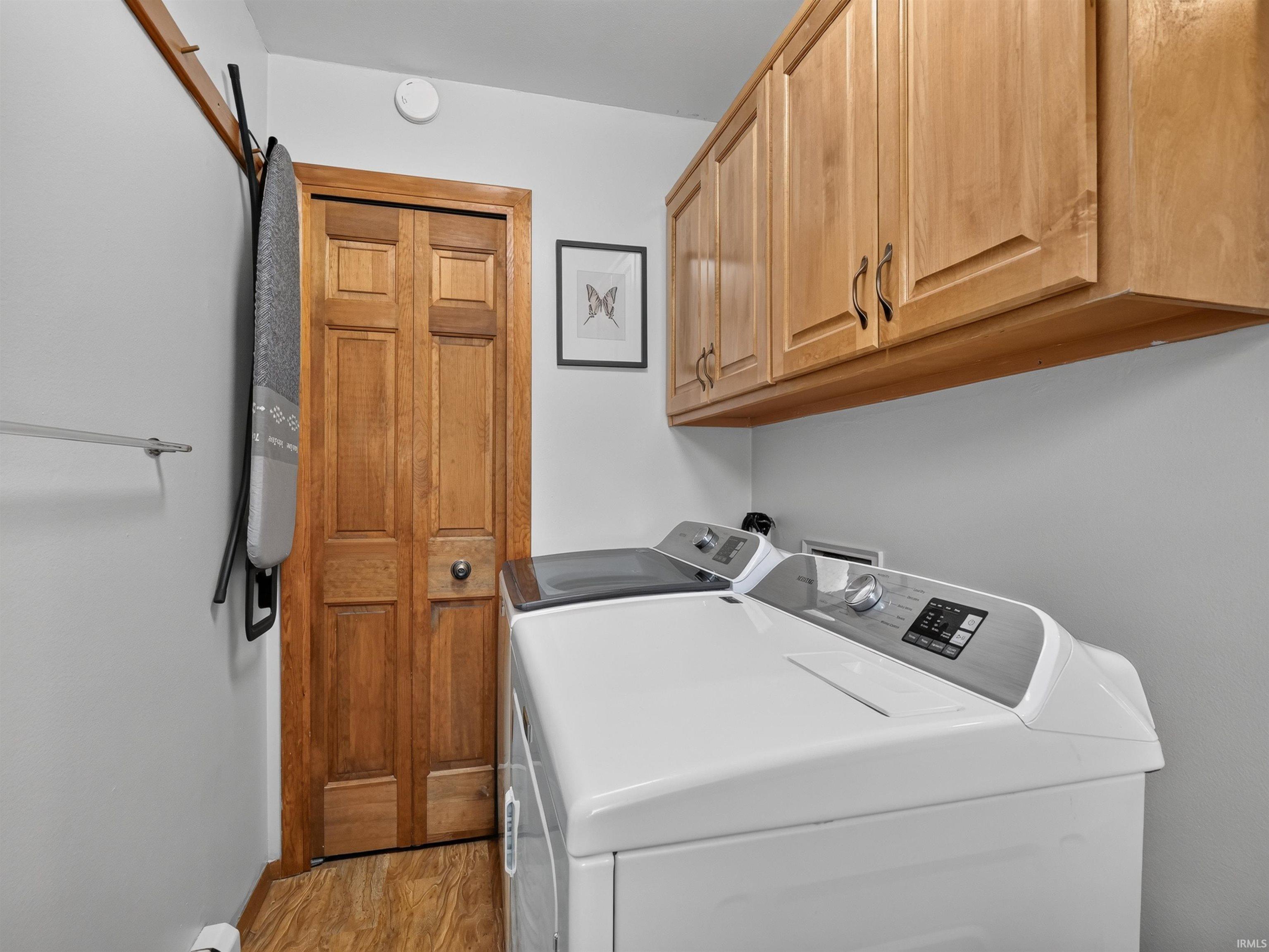 Laundry area featuring overhead wood cabinetry