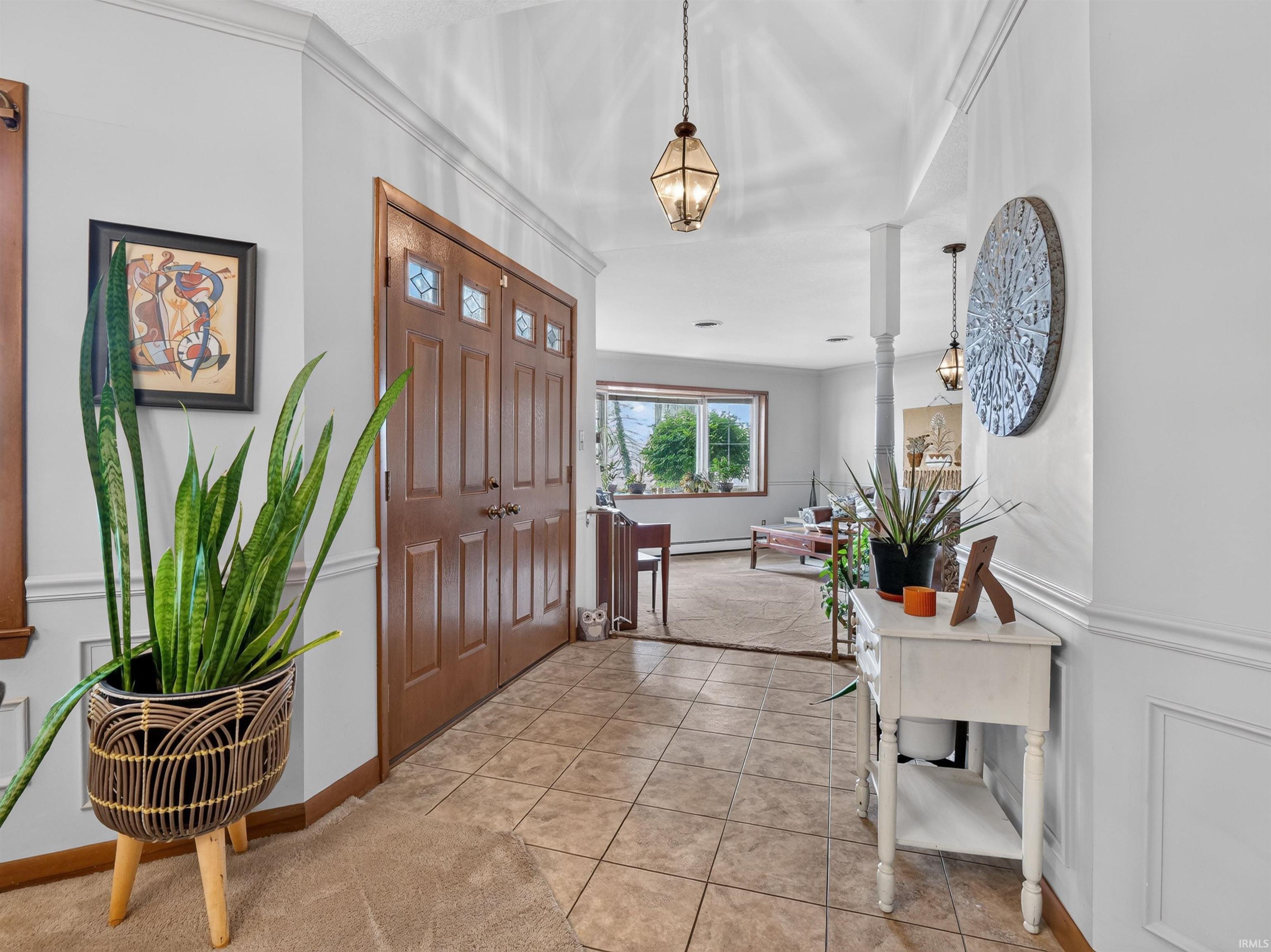 Foyer featuring double entry doors with decorative glass panels, tile flooring, and overhead pendant lighting