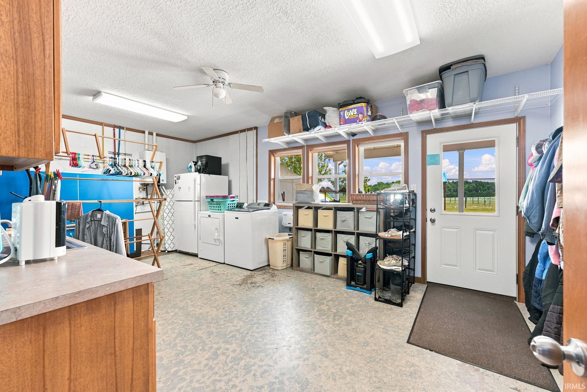 Utility room featuring wood-finish cabinetry, a utility sink, and durable flooring
