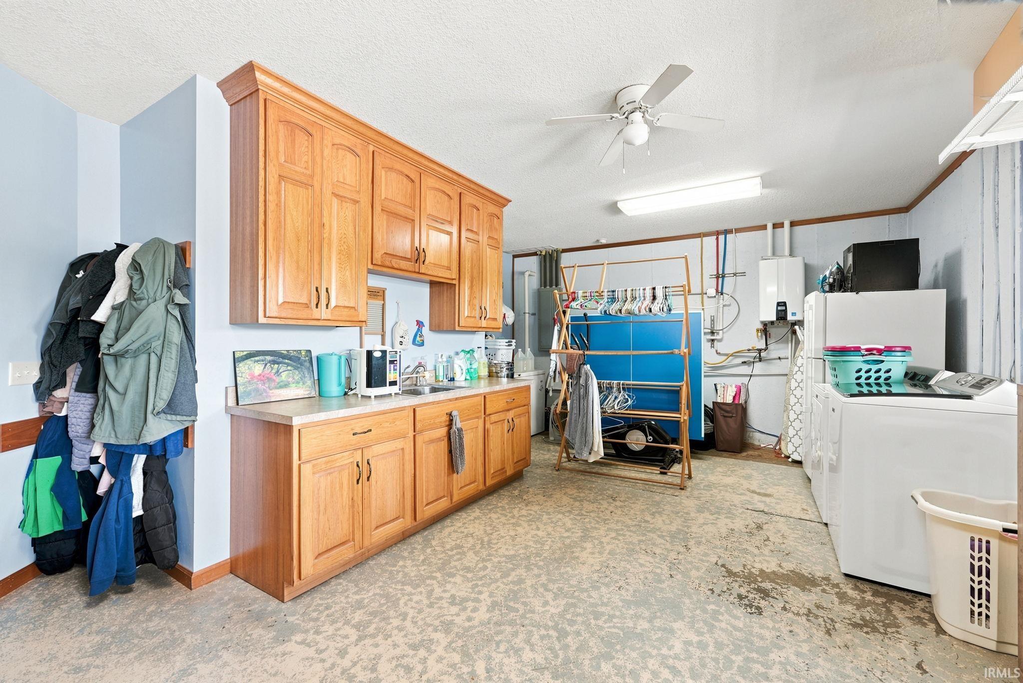 Utility room featuring extensive wood cabinetry, a utility sink, and a countertop workspace