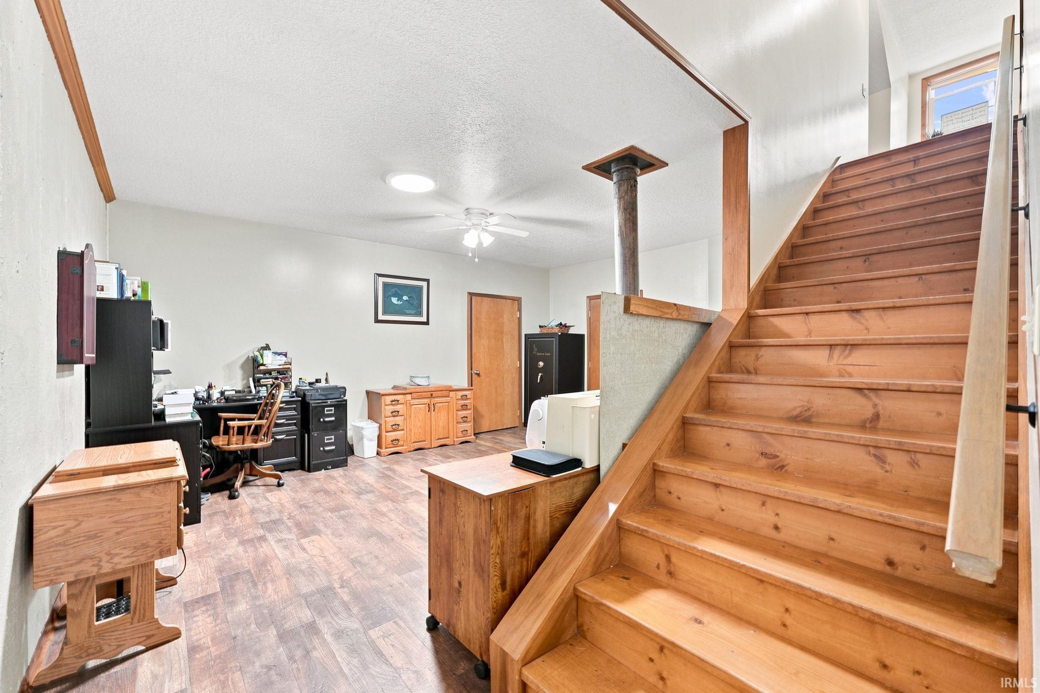 Wood staircase with a natural finish and black metal handrail brackets
