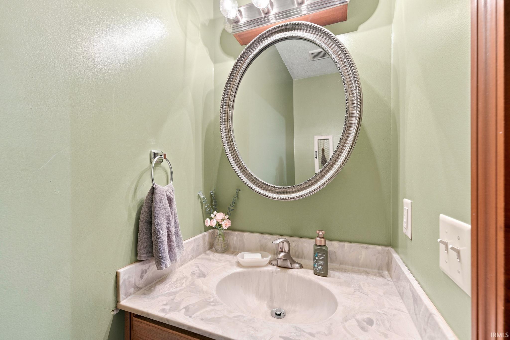 Bathroom vanity with a white countertop featuring an integrated sink and chrome faucet