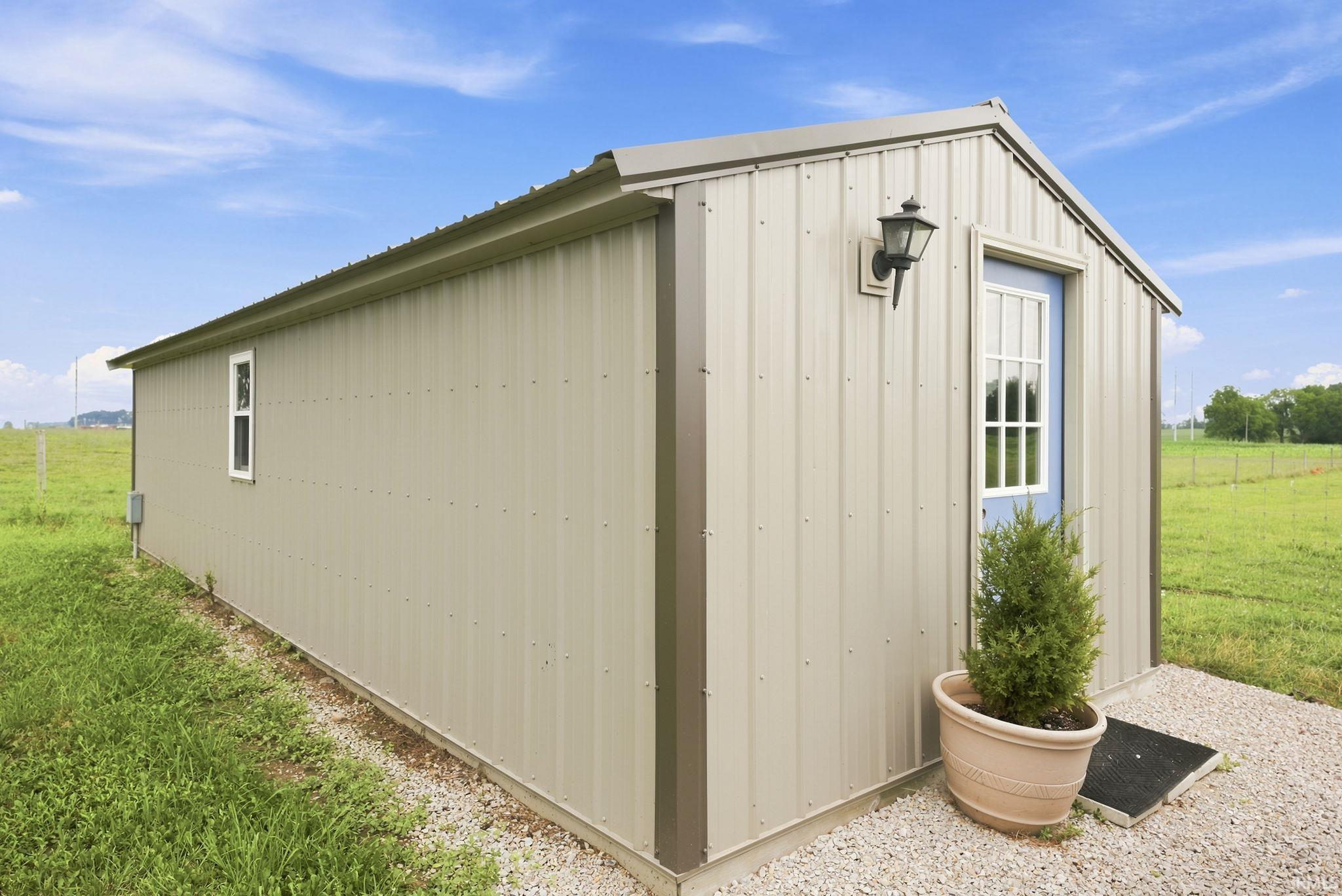 Metal-sided structure with a gabled roof and a blue-paneled door