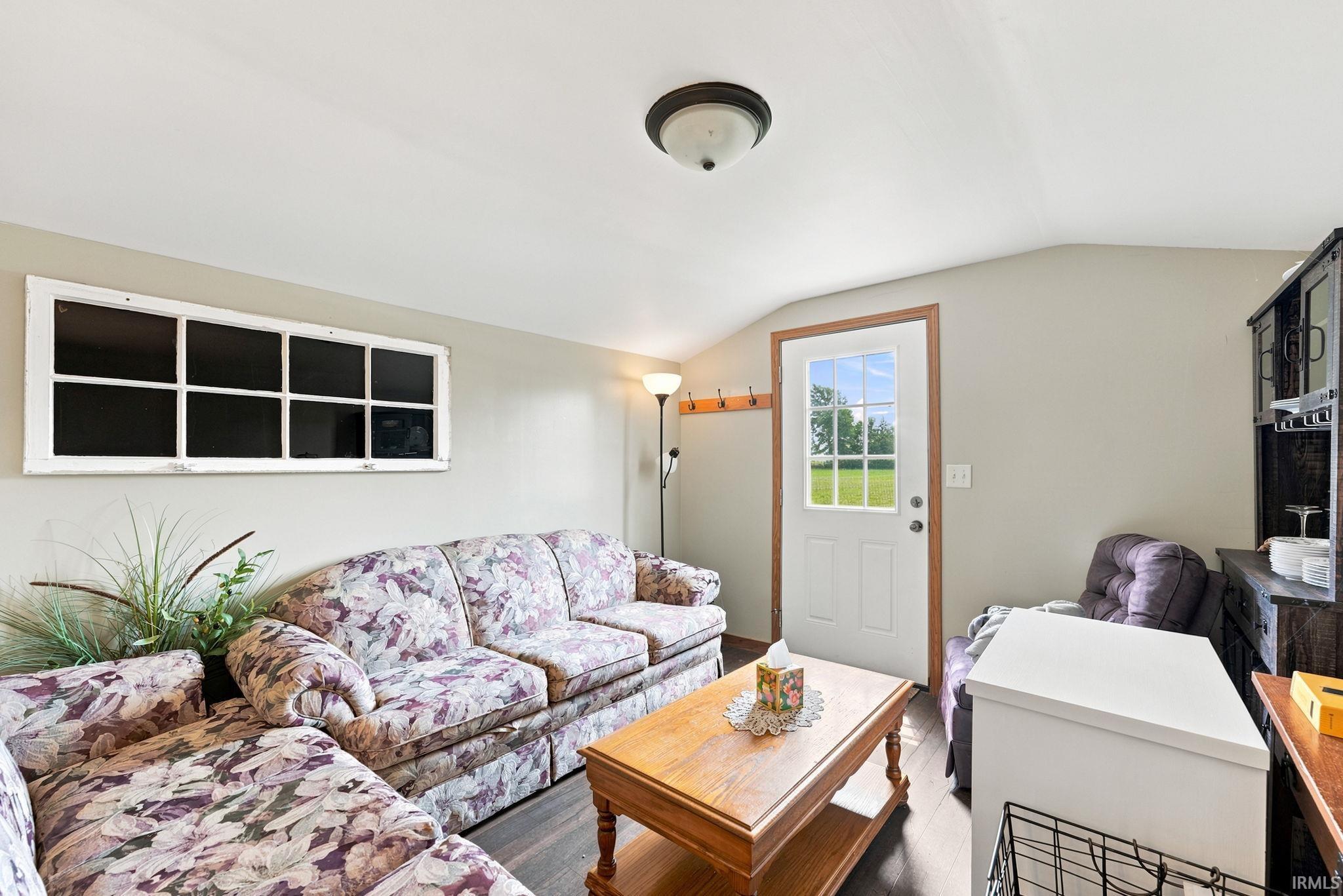 Bright interior space featuring wood-finish flooring, a white door with multiple glass panes, and a recessed ceiling light fixture