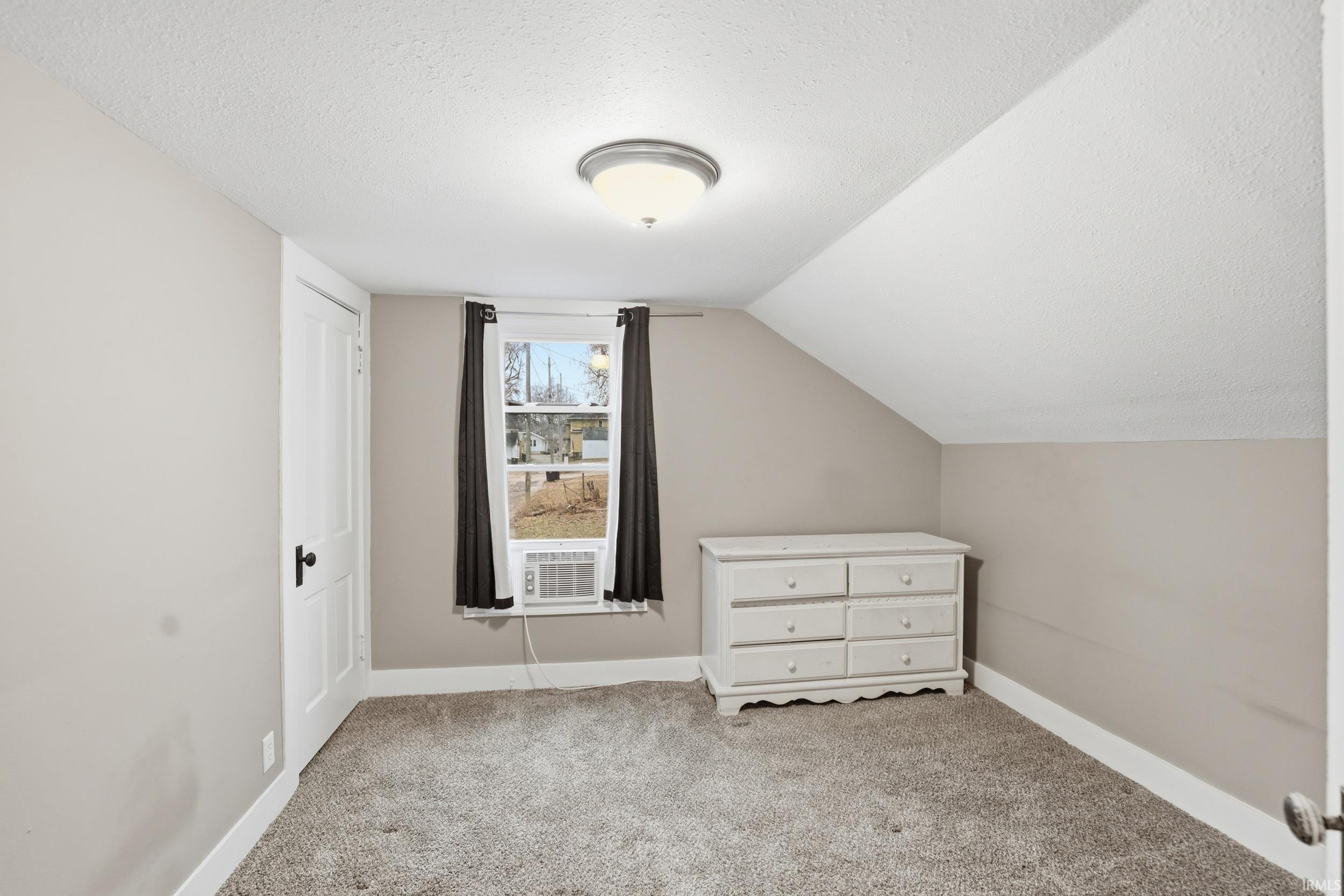 Additional living space featuring carpet flooring and baseboards