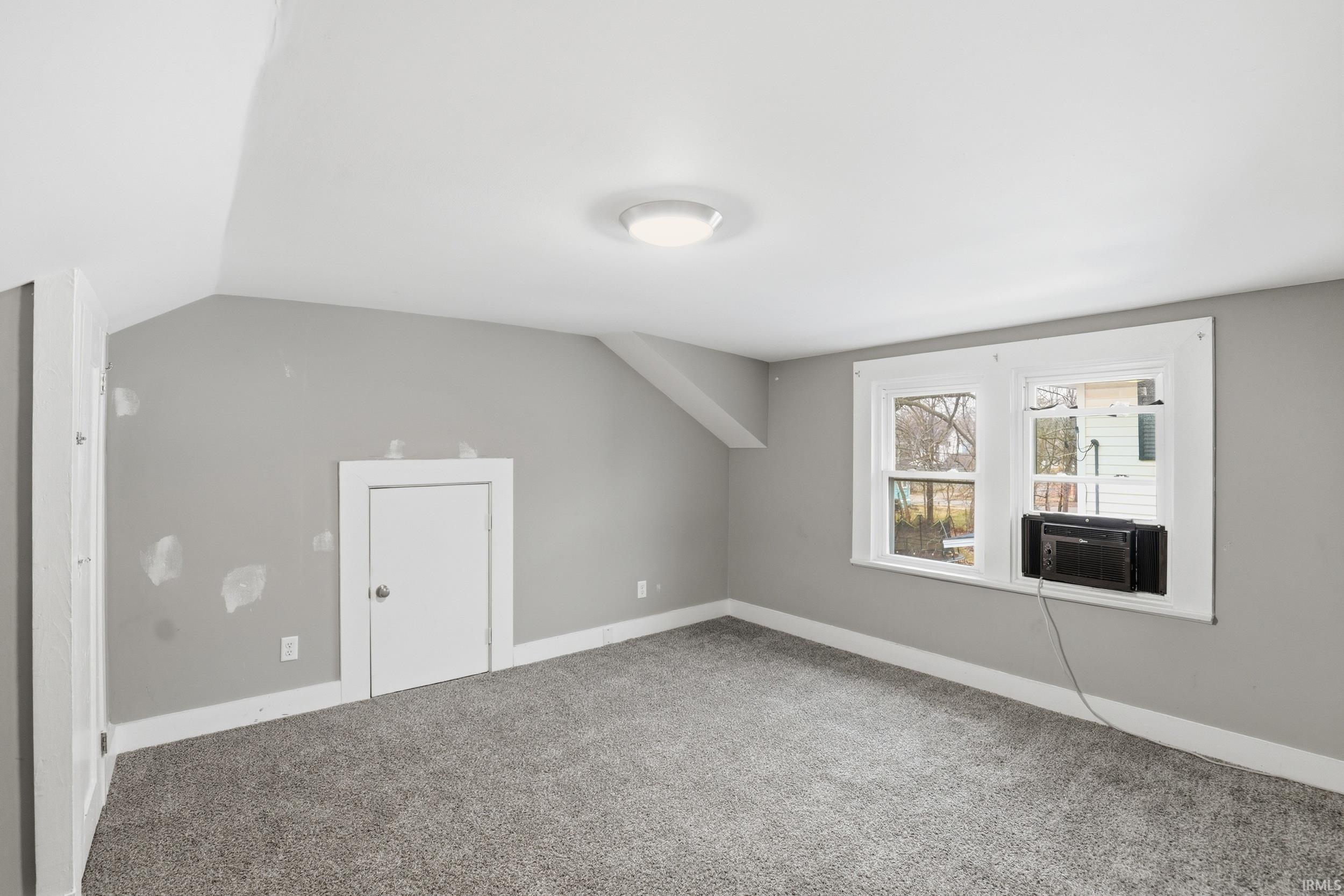 Additional living space with lofted ceiling and carpet