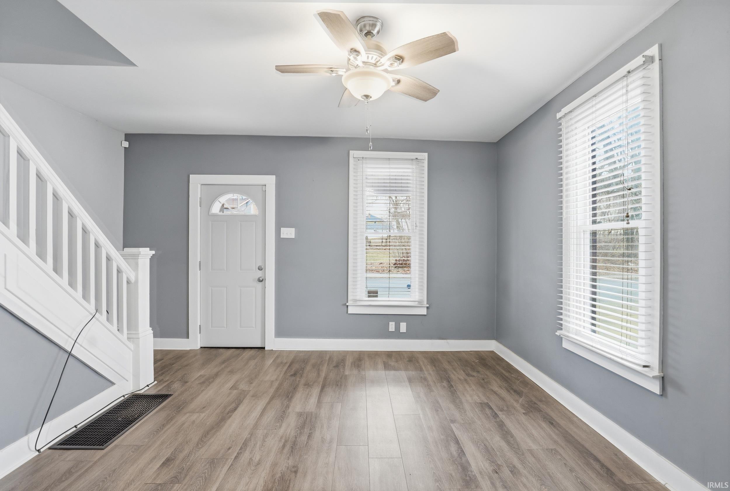 Entrance foyer with a ceiling fan and light wood finished floors