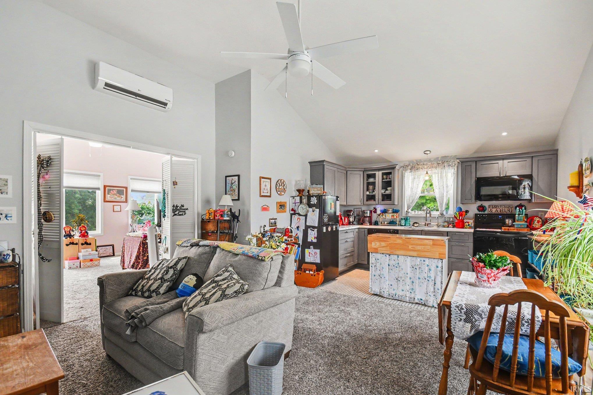 Open-concept living area with vaulted ceilings and a ceiling fan