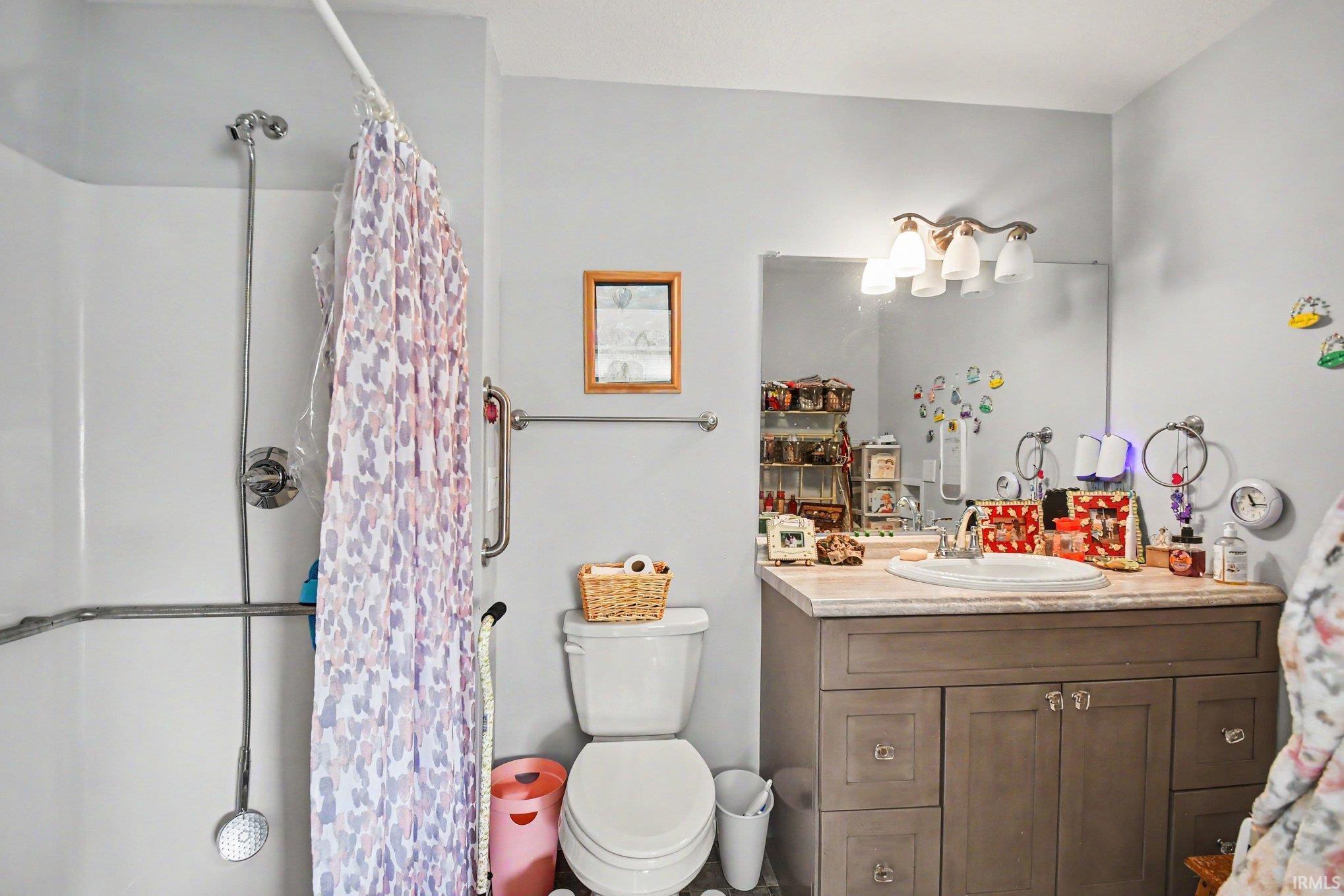 Bathroom featuring a vanity with a light-toned countertop, integrated sink, and wood-finish cabinetry
