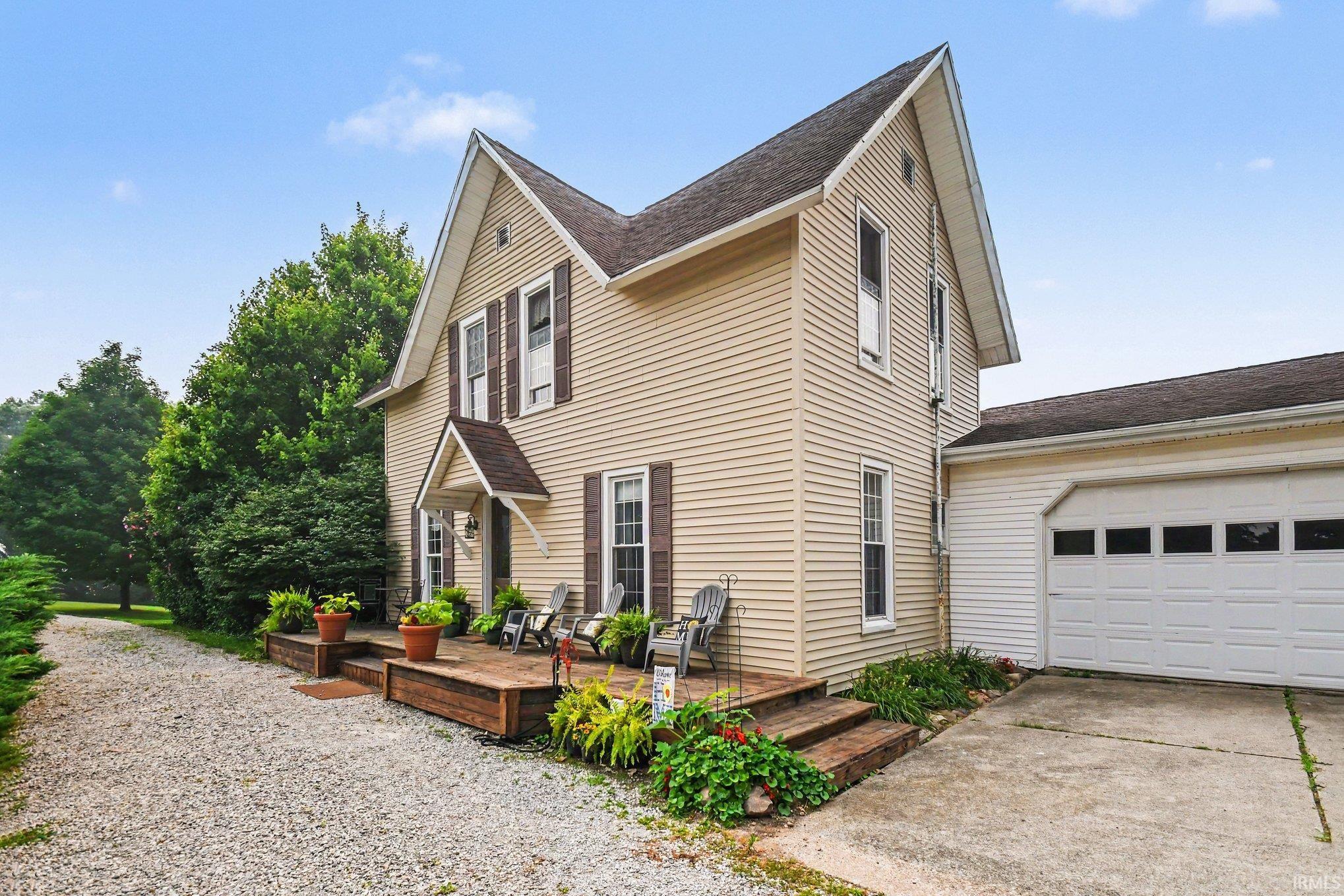 Two-story residence featuring light-colored horizontal siding and a dark shingle roof