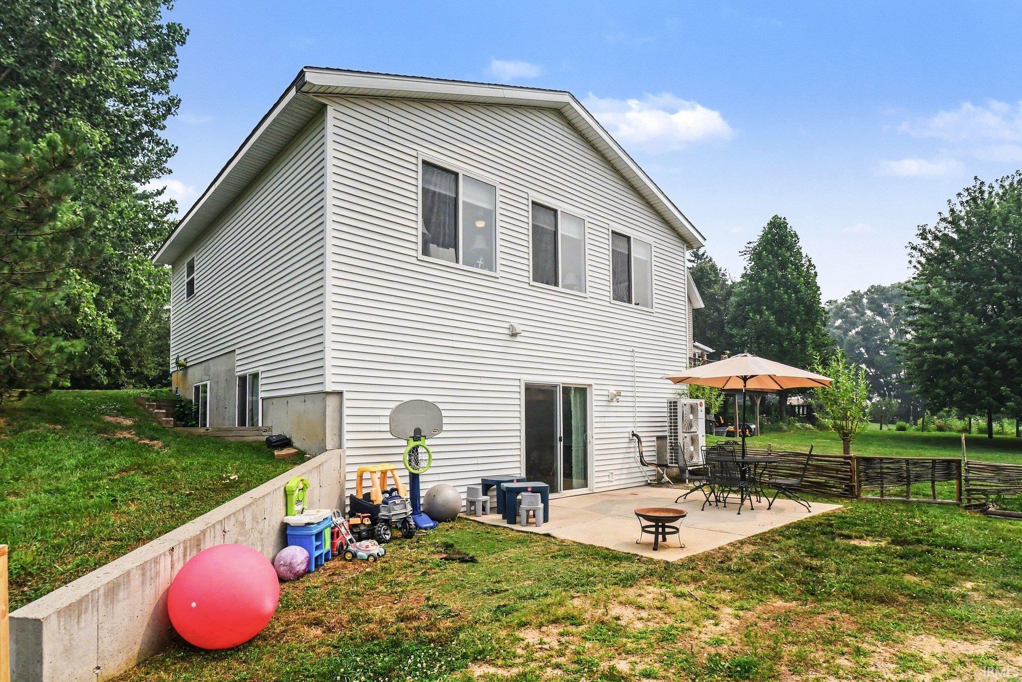 Rear exterior featuring white horizontal siding and a concrete patio