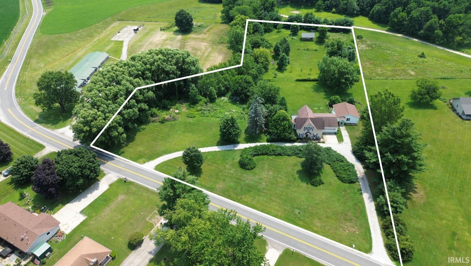Expansive property outlined with generous green space and mature trees