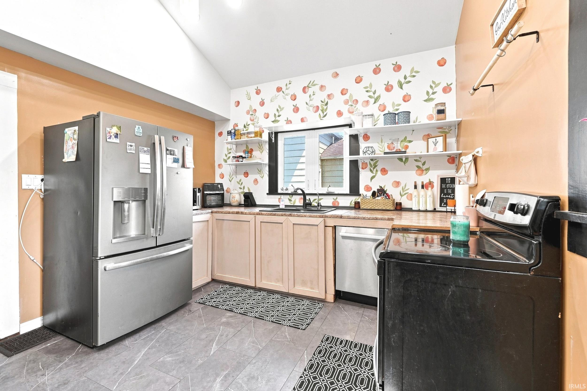 Kitchen featuring stainless steel appliances, light wood-finish cabinetry, and open shelving