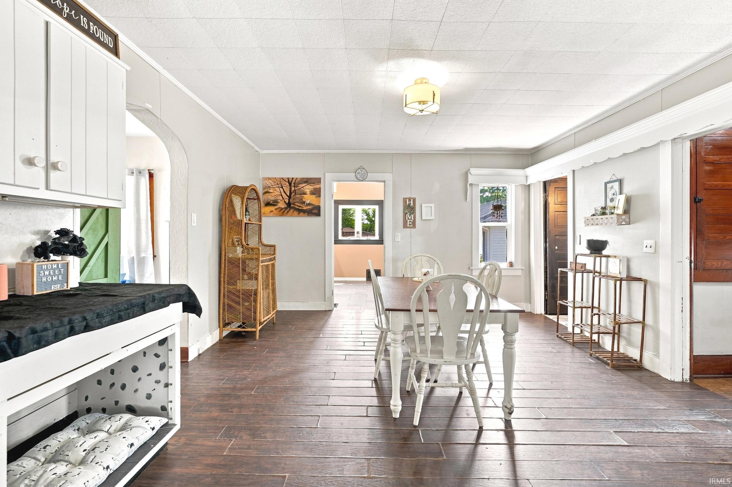 Spacious open-concept interior featuring wood-finish flooring, light gray wall paint, and white trim
