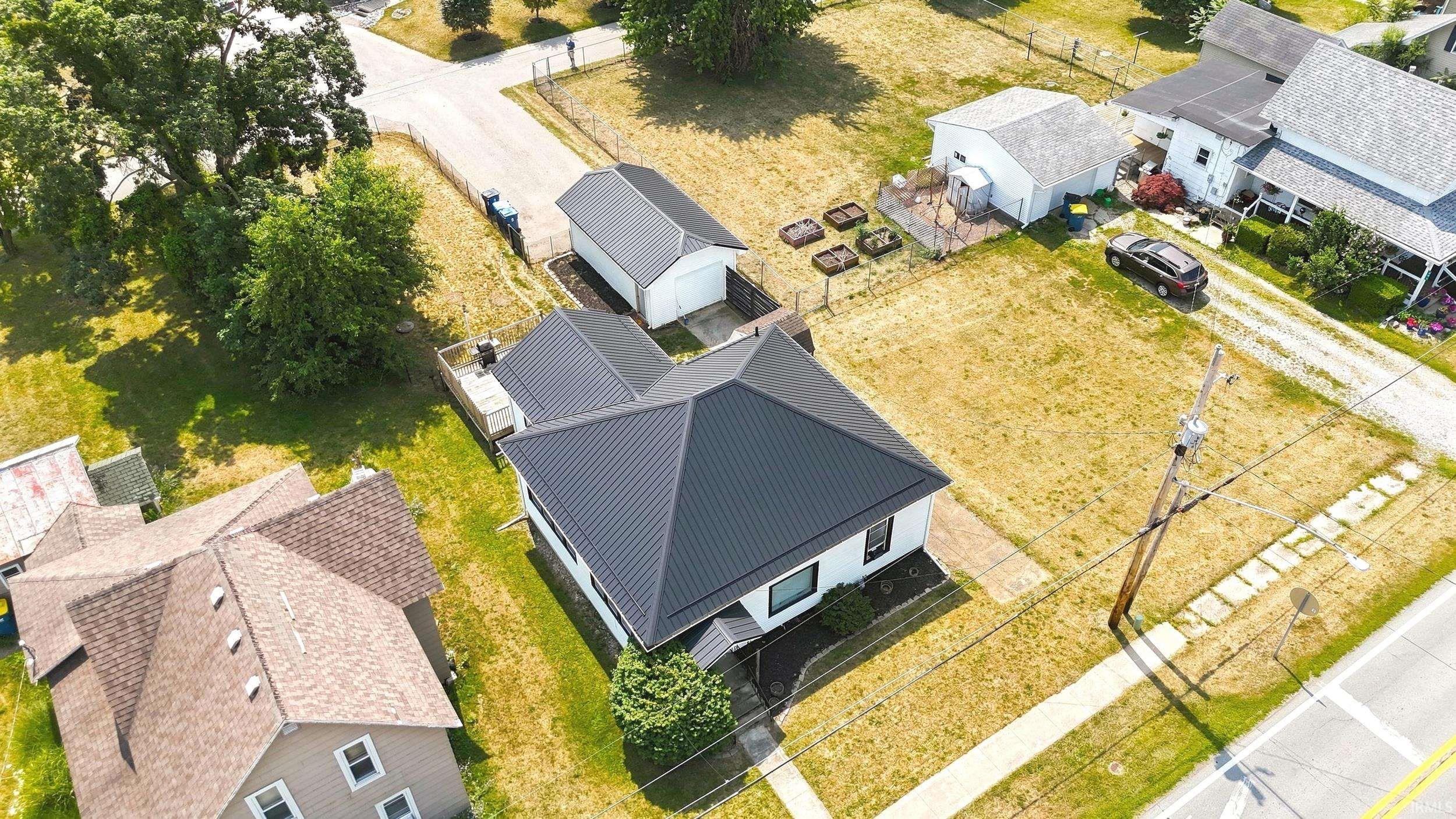 Single-story residence featuring a dark metal roof, white exterior siding, and dark trim