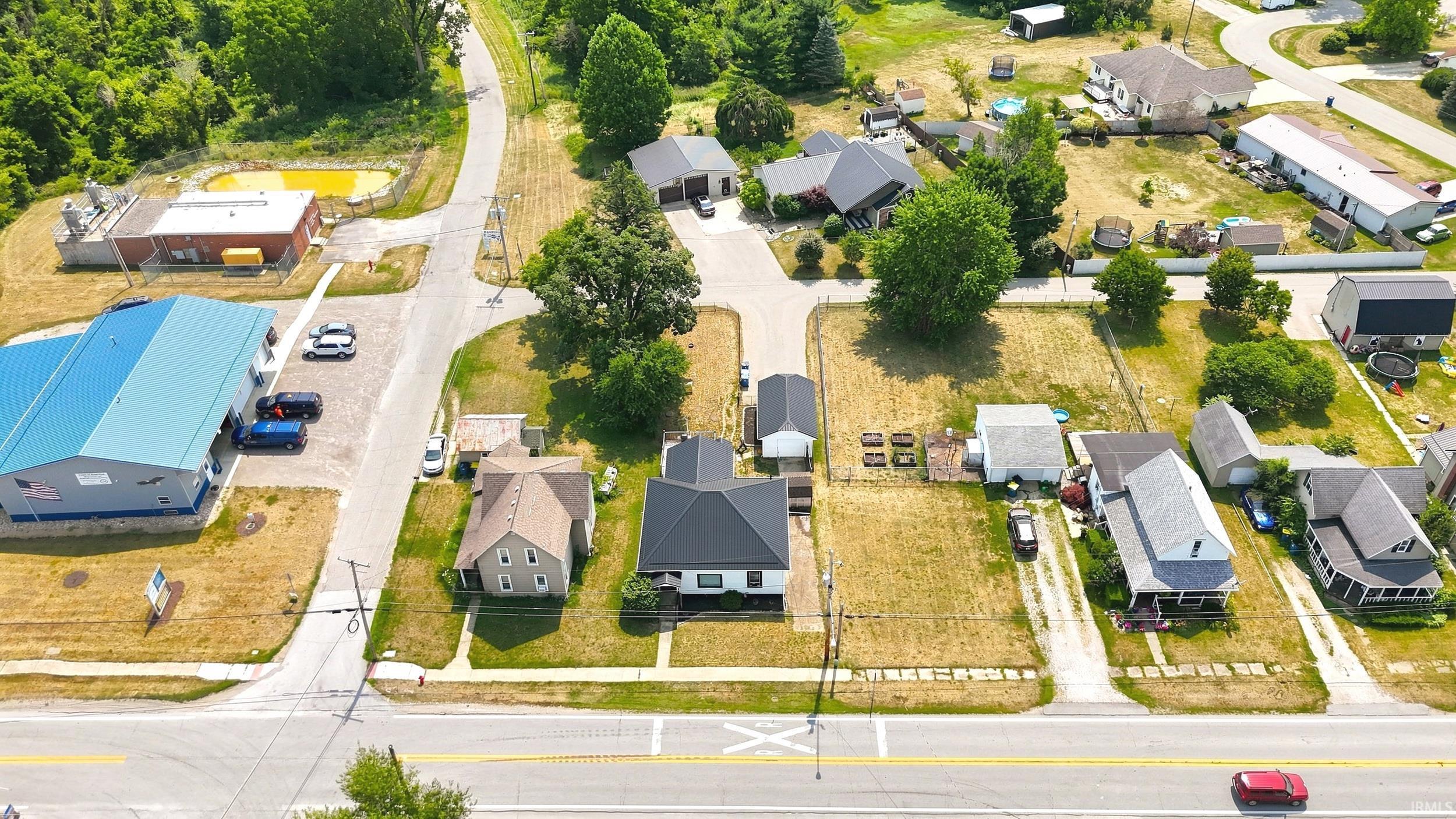 Aerial perspective showcasing a residential street with multiple single-family homes, each featuring a private driveway and green space