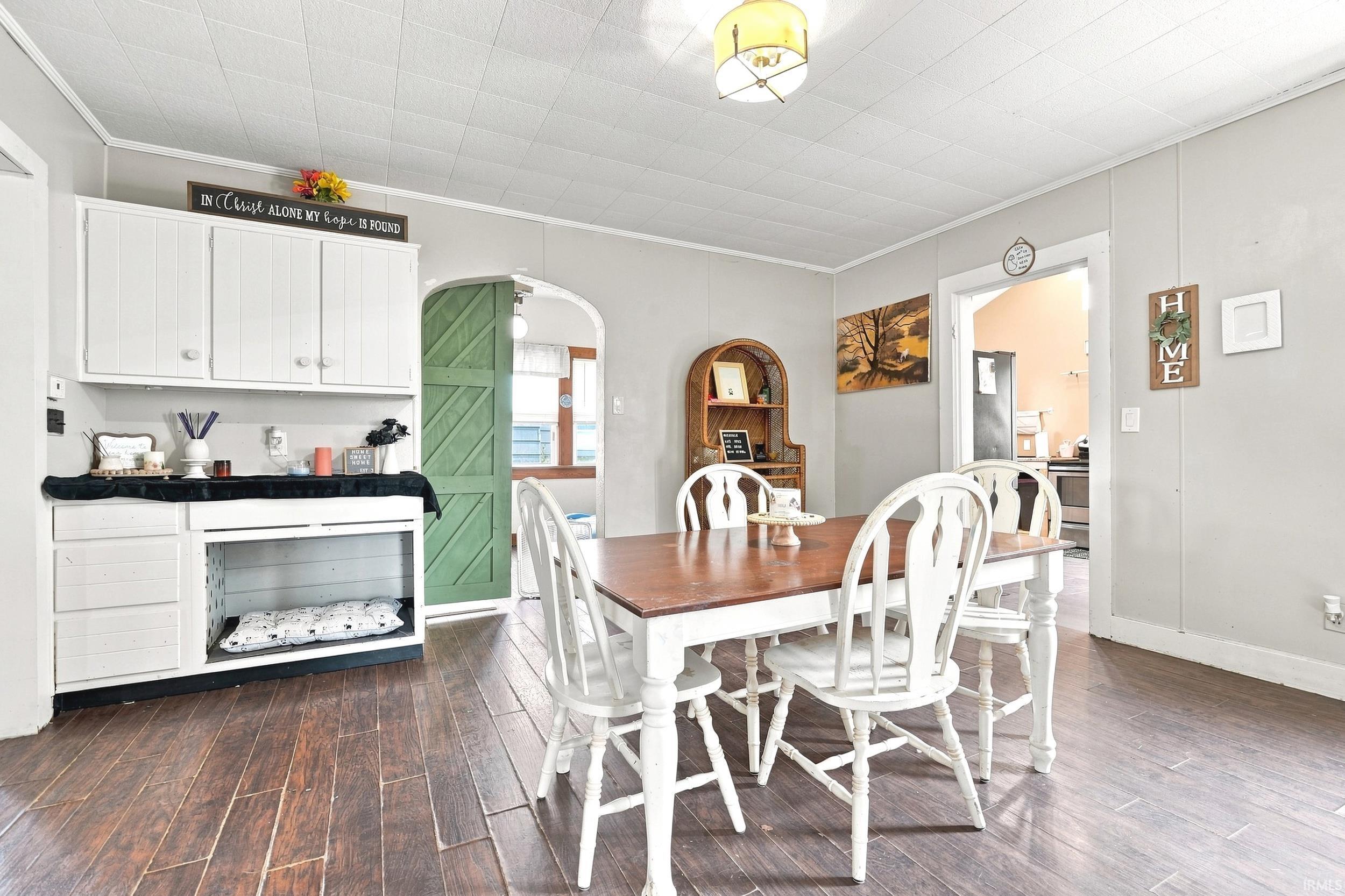 Dining area featuring wood-finish flooring, light gray walls, and white ceiling tiles