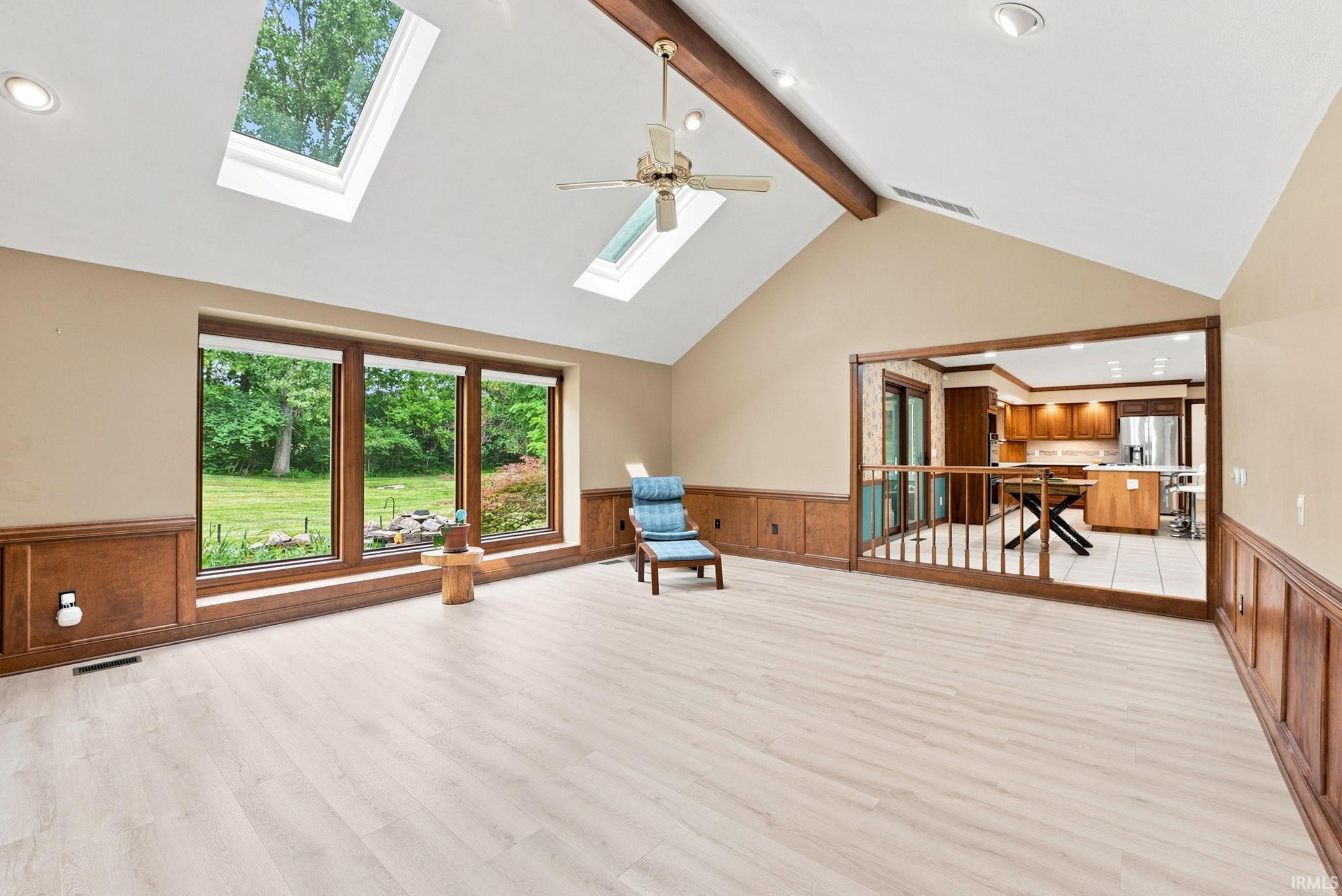 Vaulted ceilings with exposed wood beams and skylights complement the wood-finish flooring