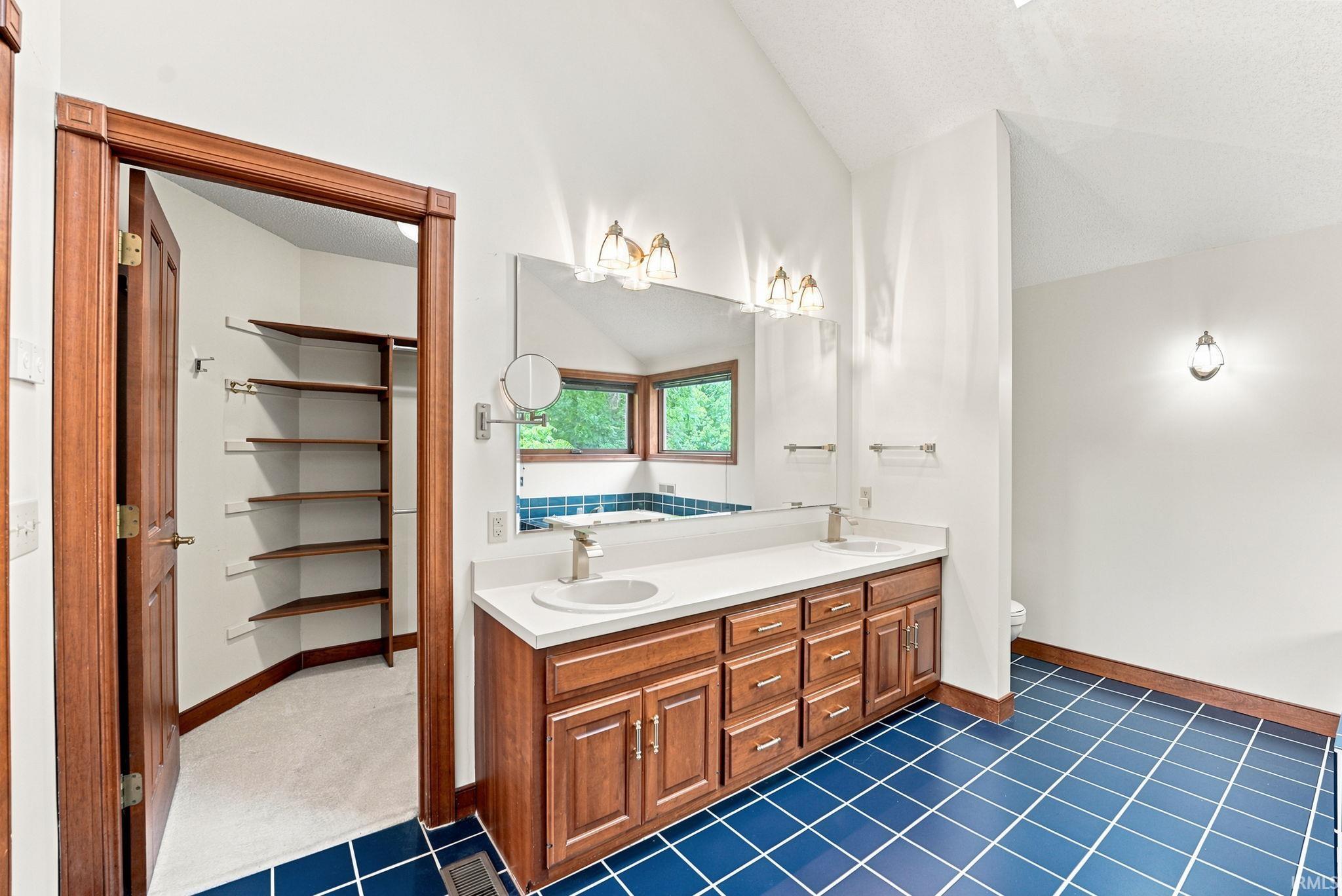 Dual vanity with white undermount sinks and a light-toned countertop, set against a full-width mirror
