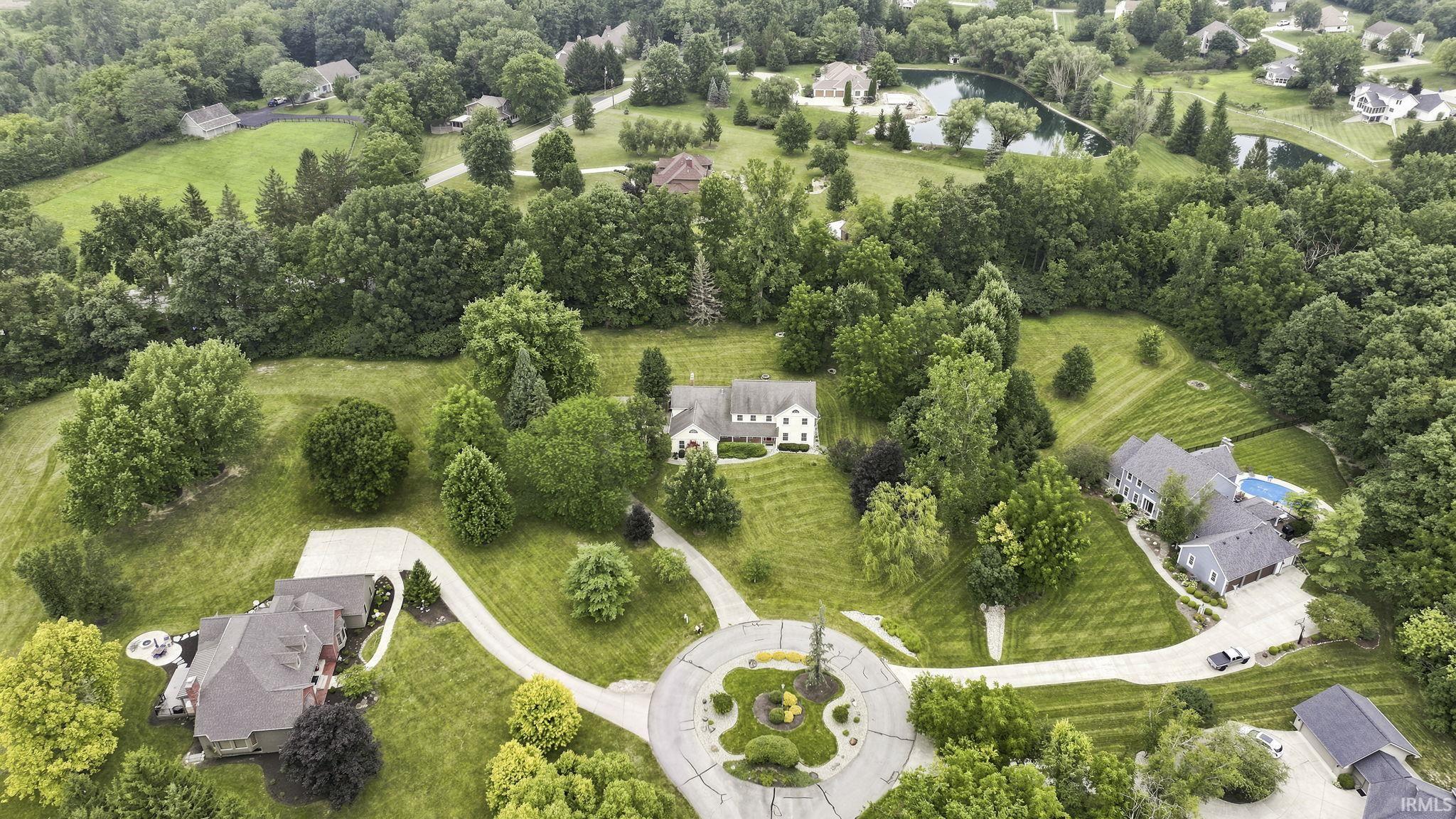 Expansive aerial rendering of a residential landscape featuring a cul-de-sac, multiple residences, mature trees, and manicured lawns