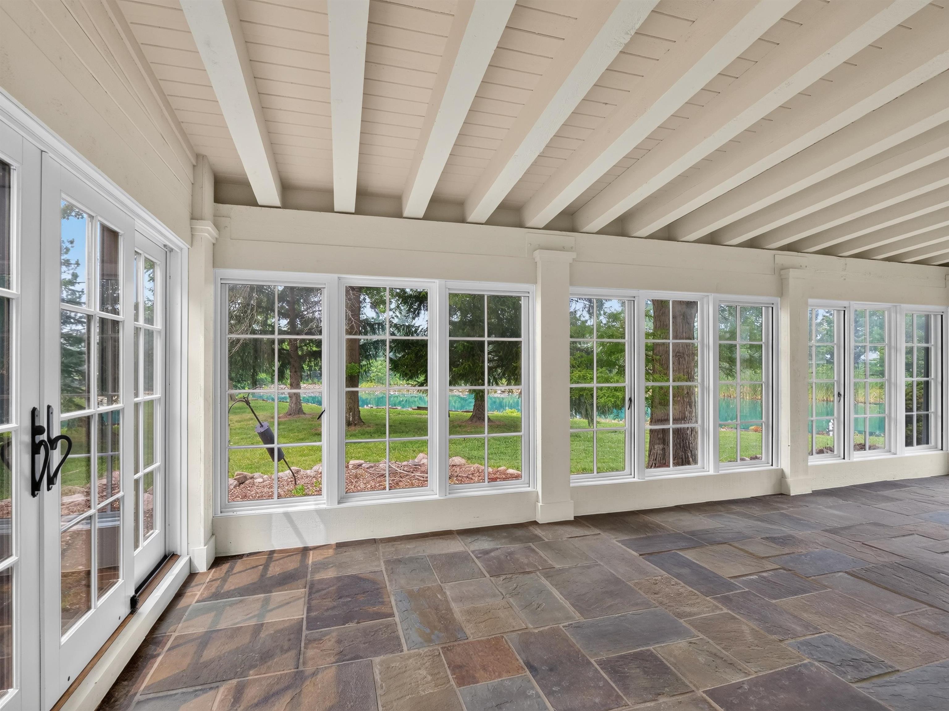 Enclosed porch featuring multi-pane windows and French doors