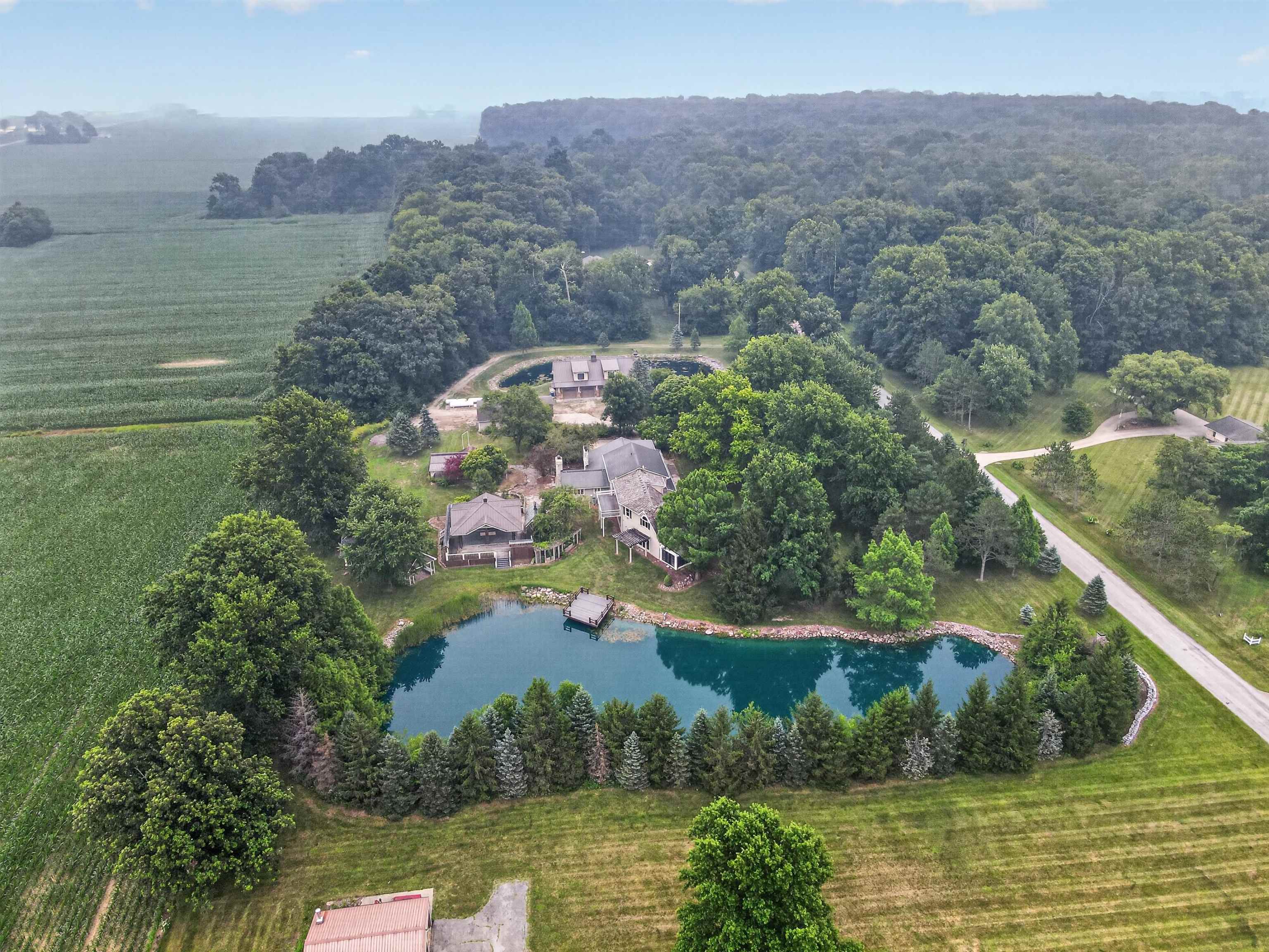 Expansive property featuring two distinct ponds with docks, surrounded by mature trees and manicured landscaping