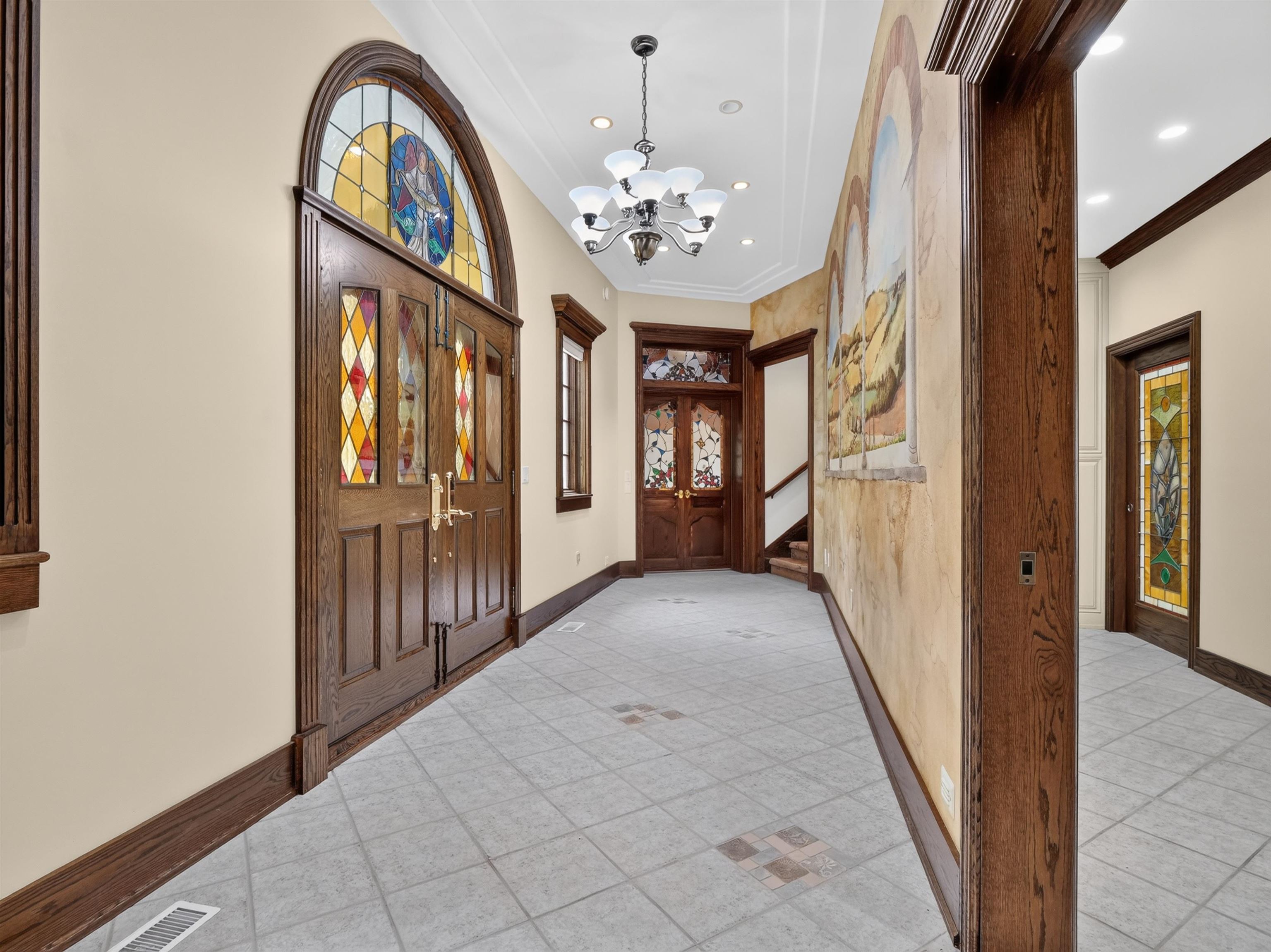Grand entryway featuring double stained-glass doors with an arched transom