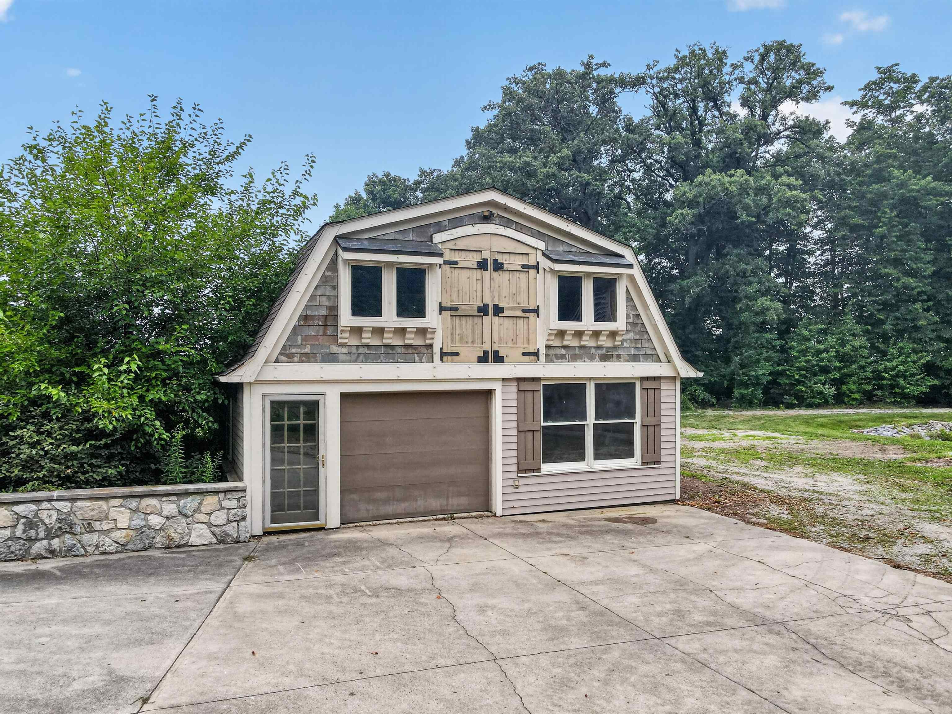 Two-story accessory building featuring a gambrel roof and shingle siding