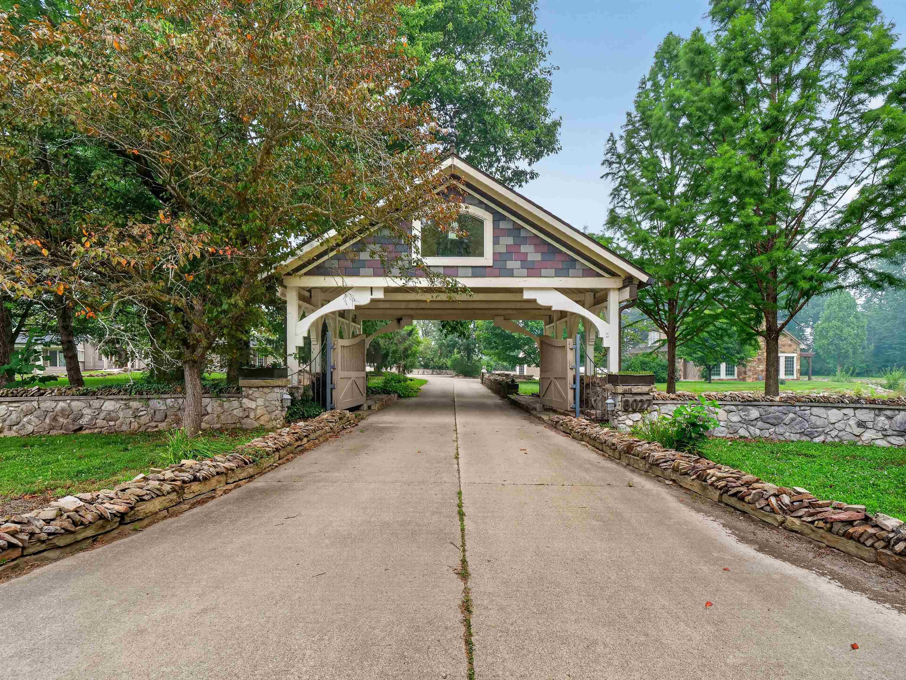 Covered entryway featuring a multicolored shingle roof and white architectural supports