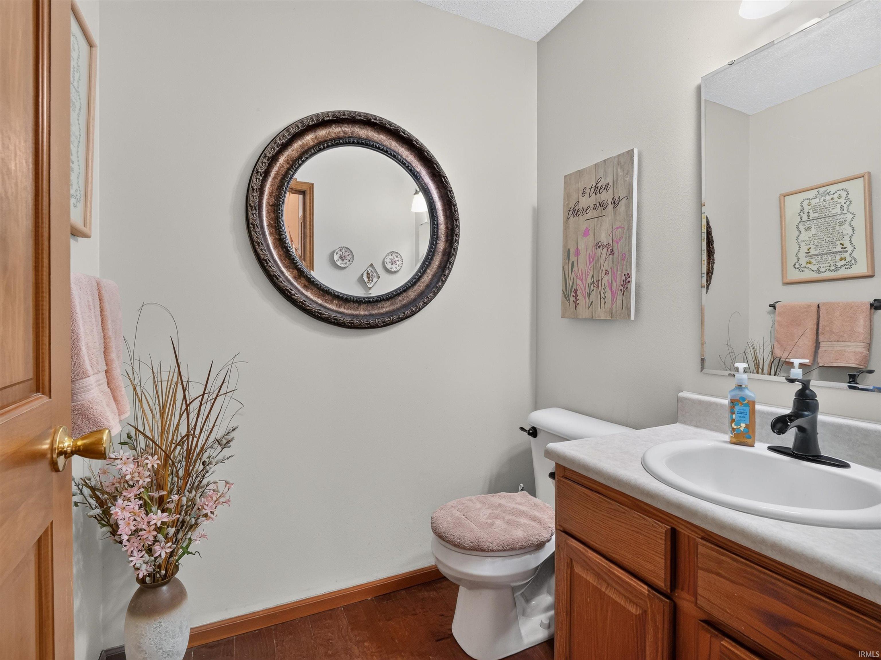 Bathroom featuring a single basin vanity with wood-finish cabinetry, a black faucet, and a large wall-mounted mirror