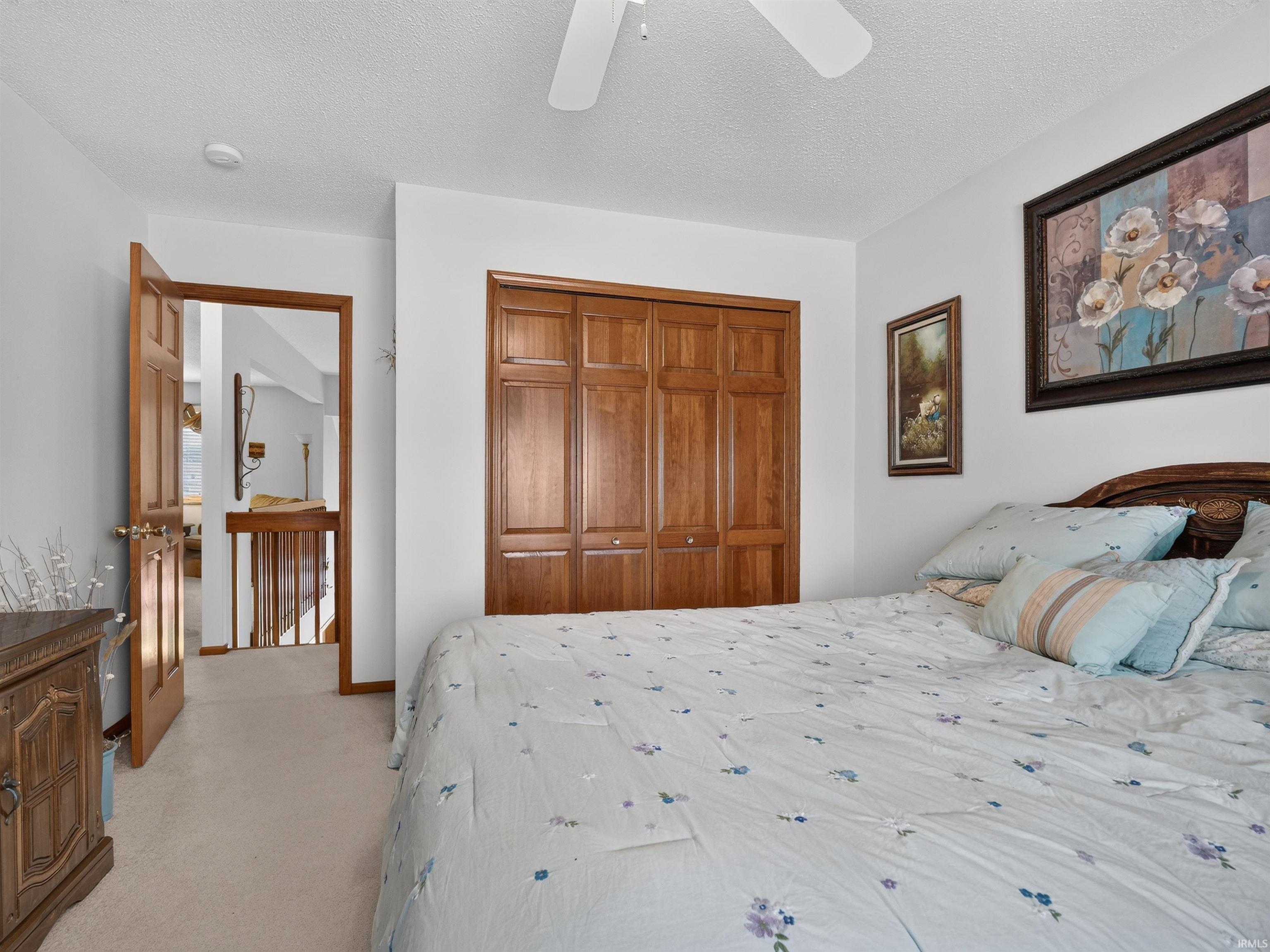 Bedroom featuring light-colored carpet flooring and a ceiling fan
