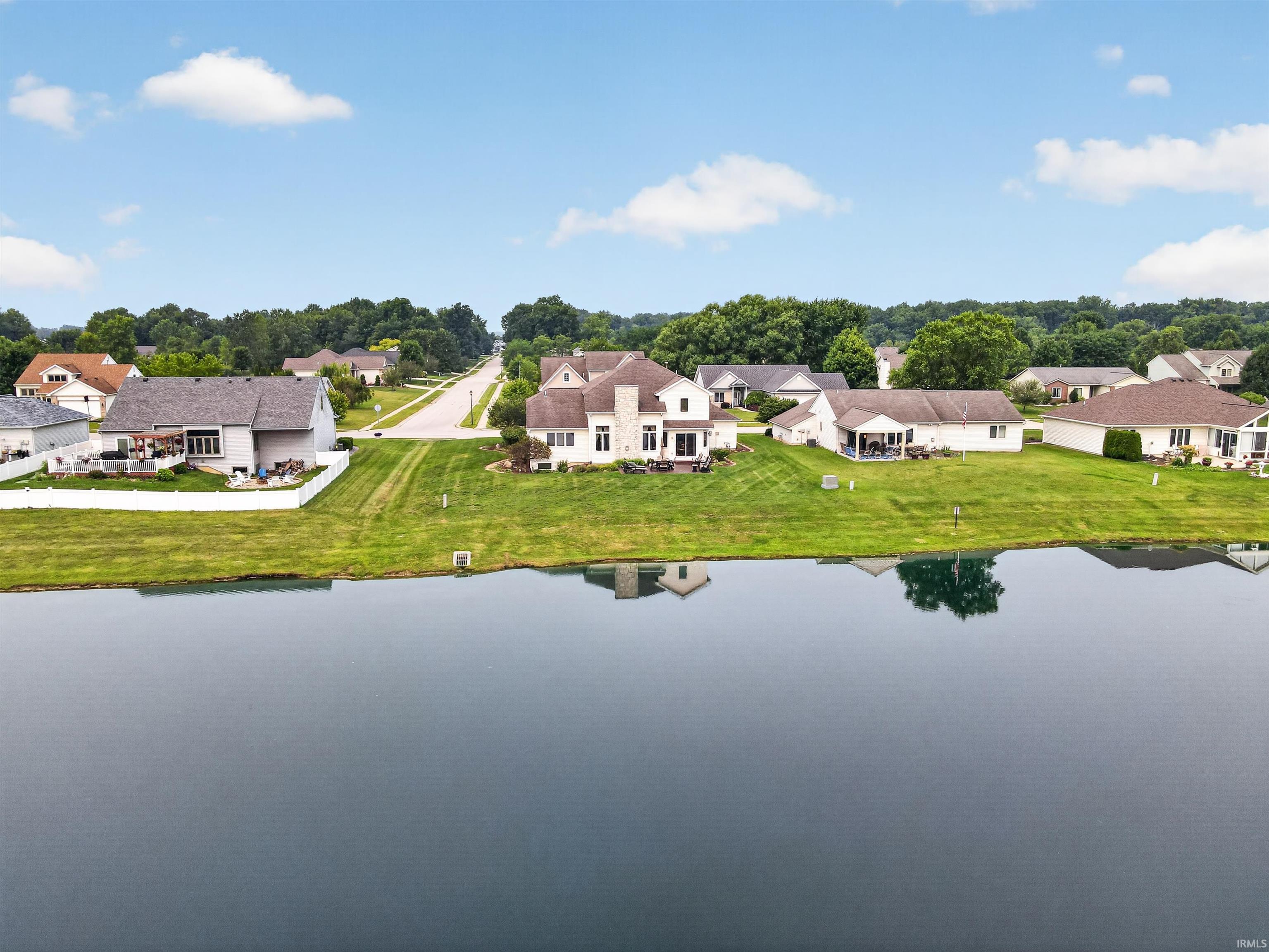 Waterfront property featuring a serene body of water and expansive green space