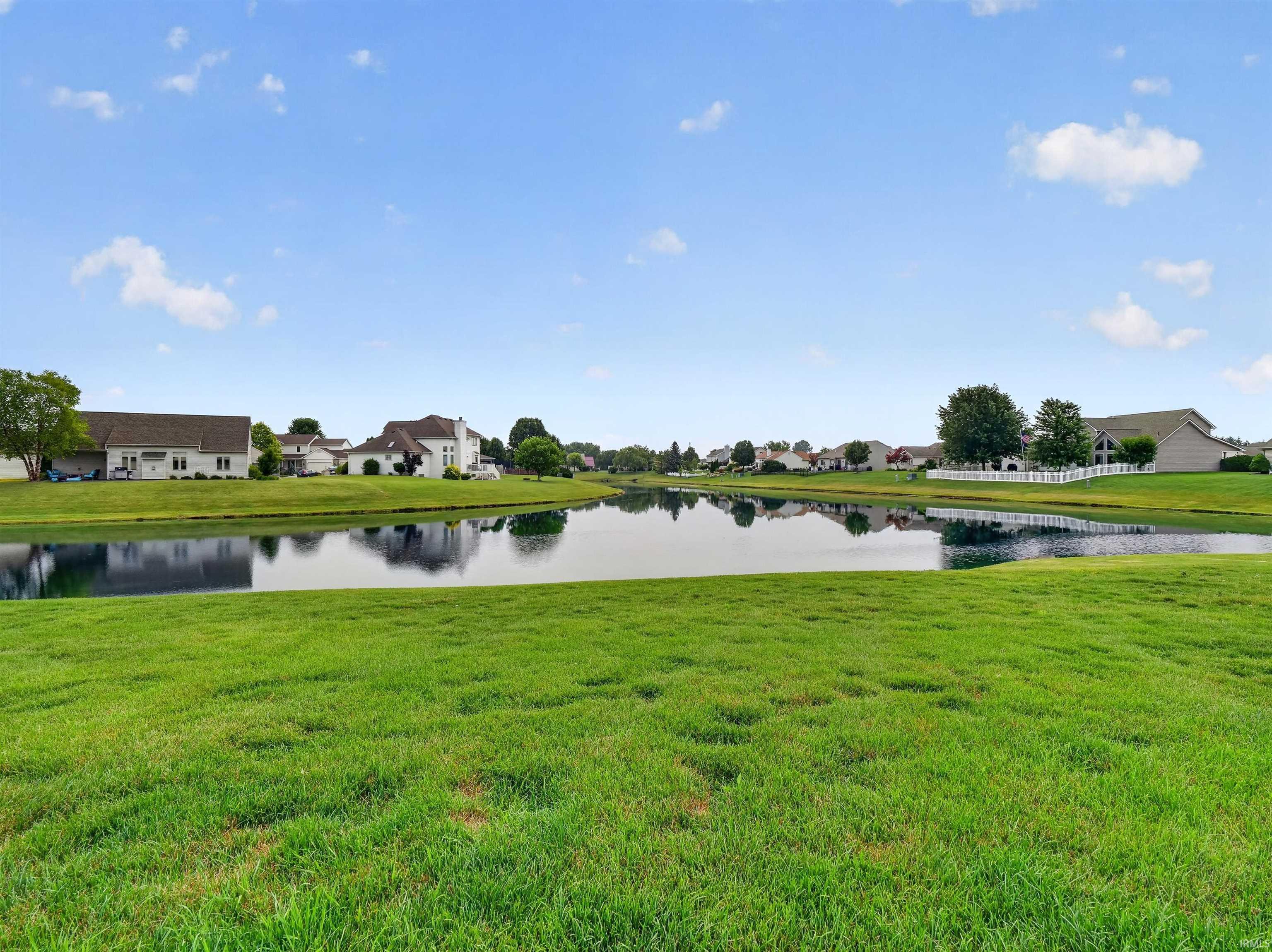 Expansive green space featuring a large pond