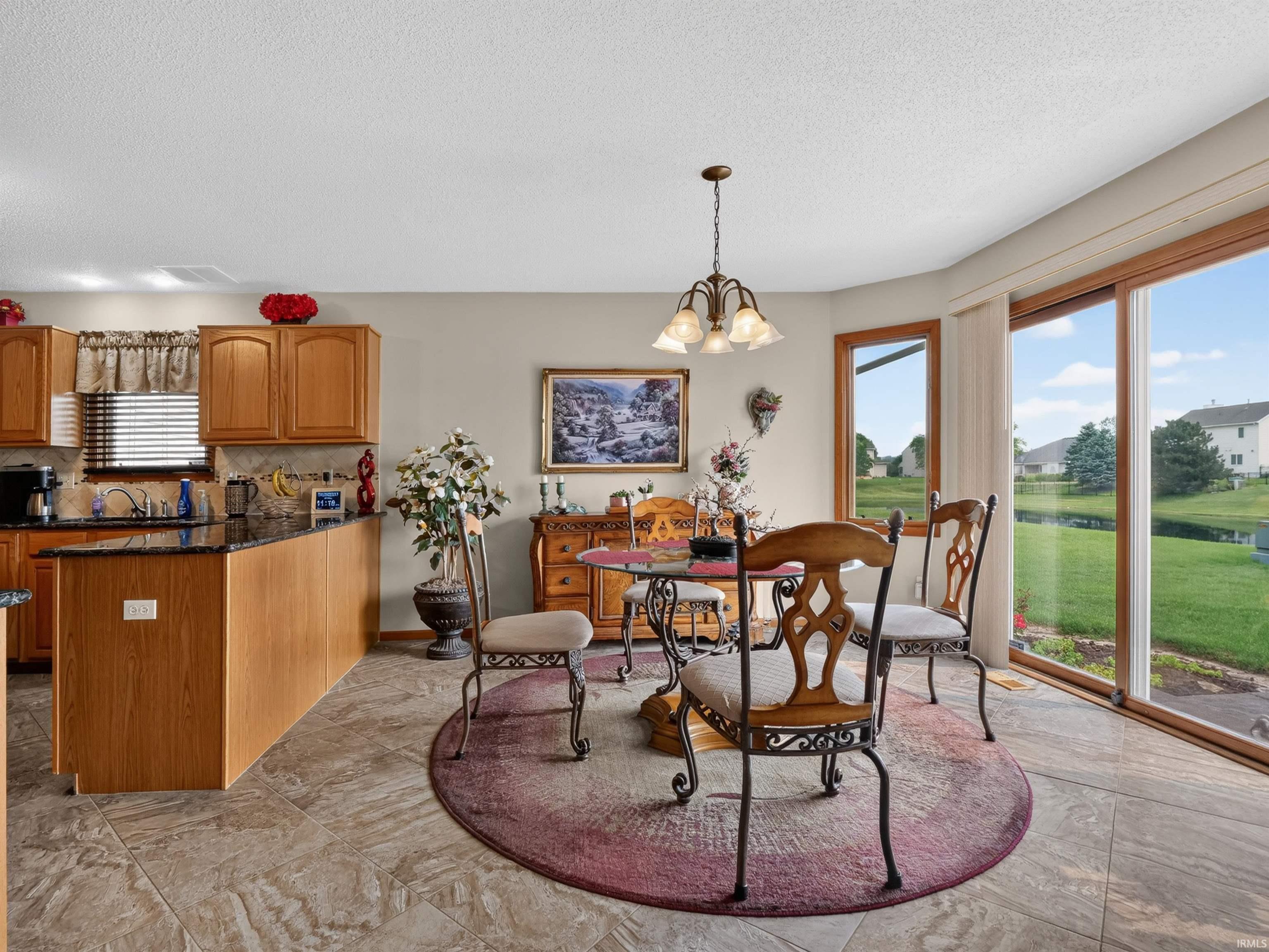 Bright dining area featuring tile flooring, a bay window, and sliding glass doors that open to the exterior