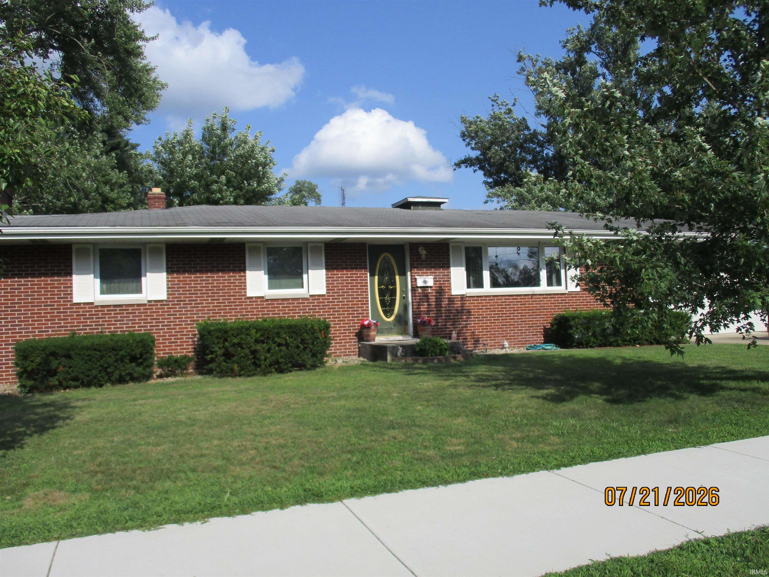 Brick exterior featuring white window shutters