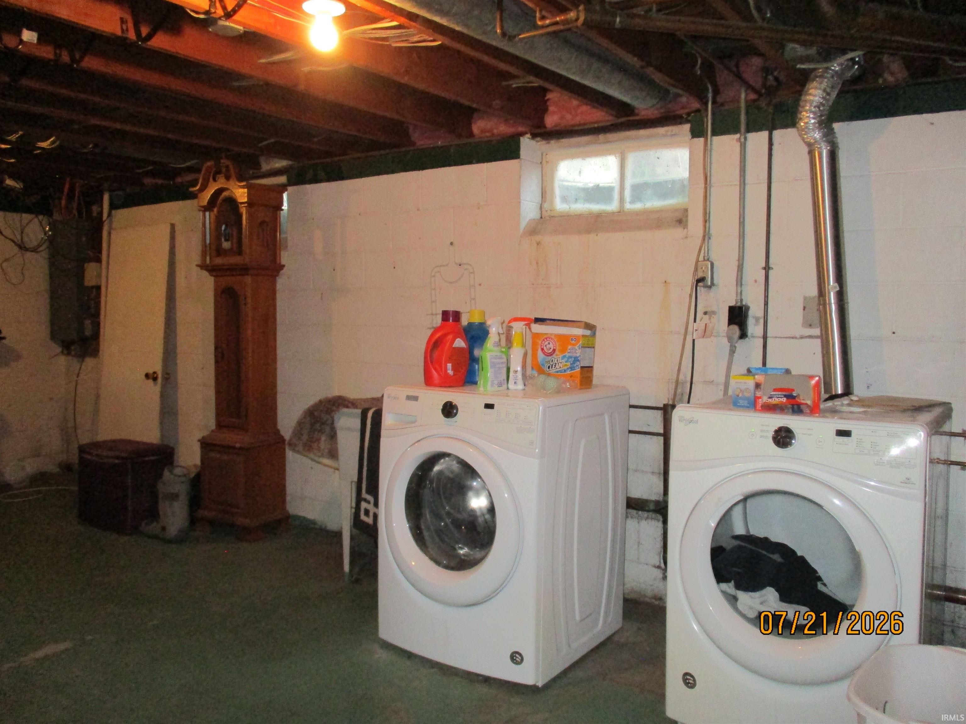 Utility area featuring concrete block walls and a painted floor