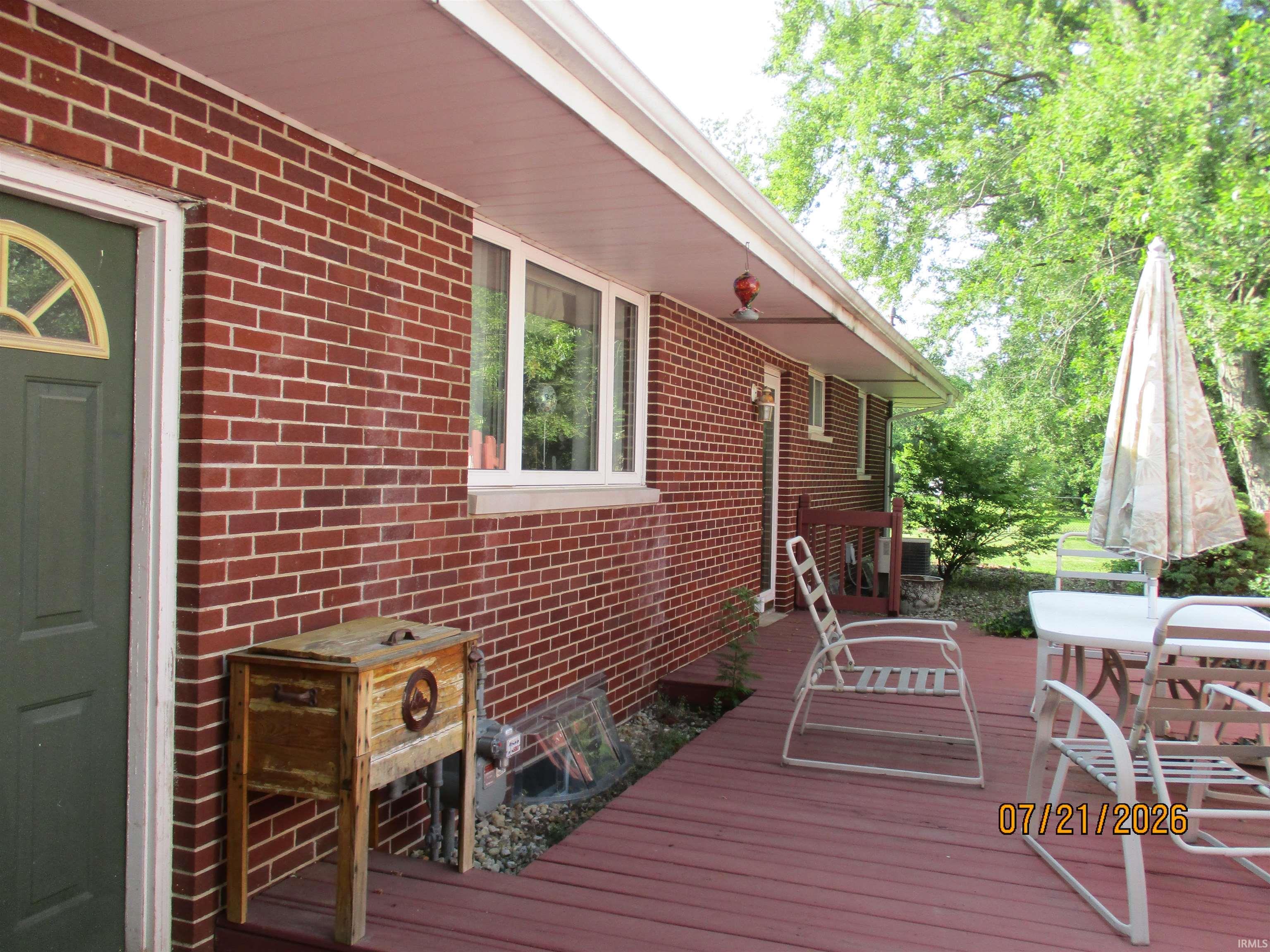 Exterior brick facade with a green entry door
