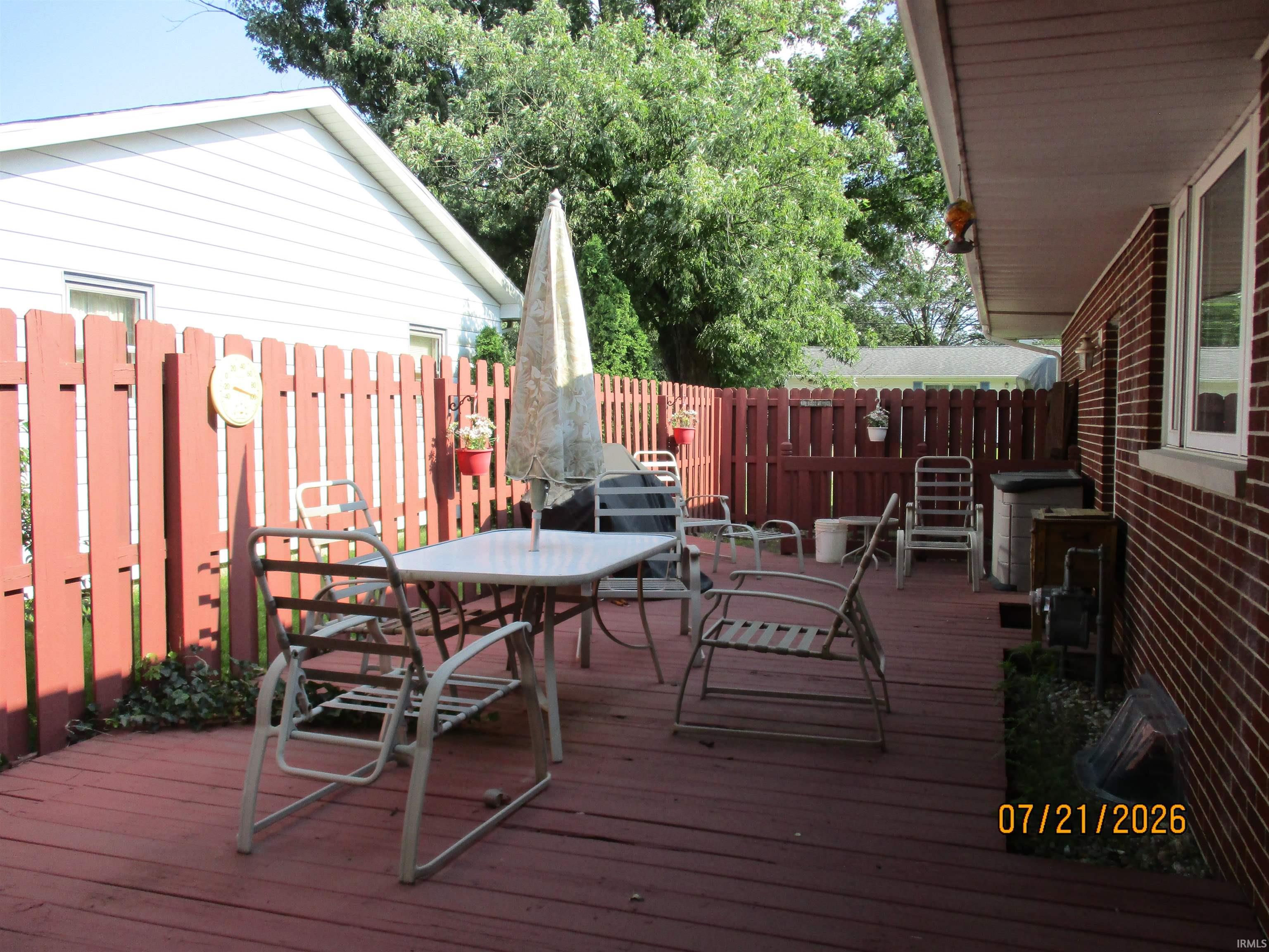 Expansive wood deck with a red-stained finish, providing an outdoor living area