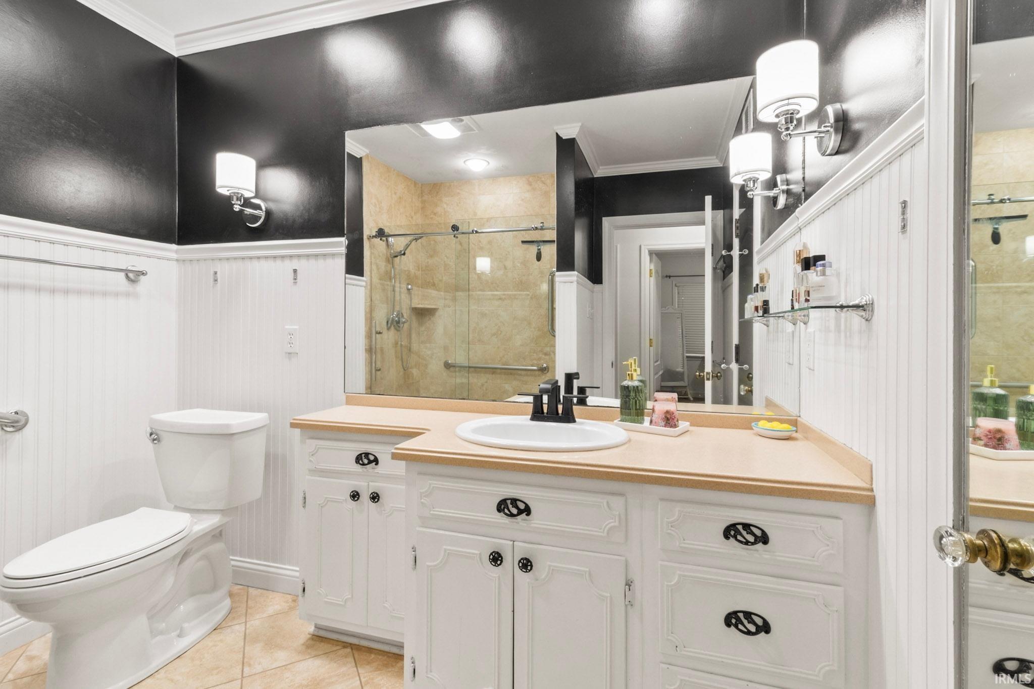 Bathroom featuring a double vanity with ample storage cabinetry, a recessed sink, and a large wall-mounted mirror
