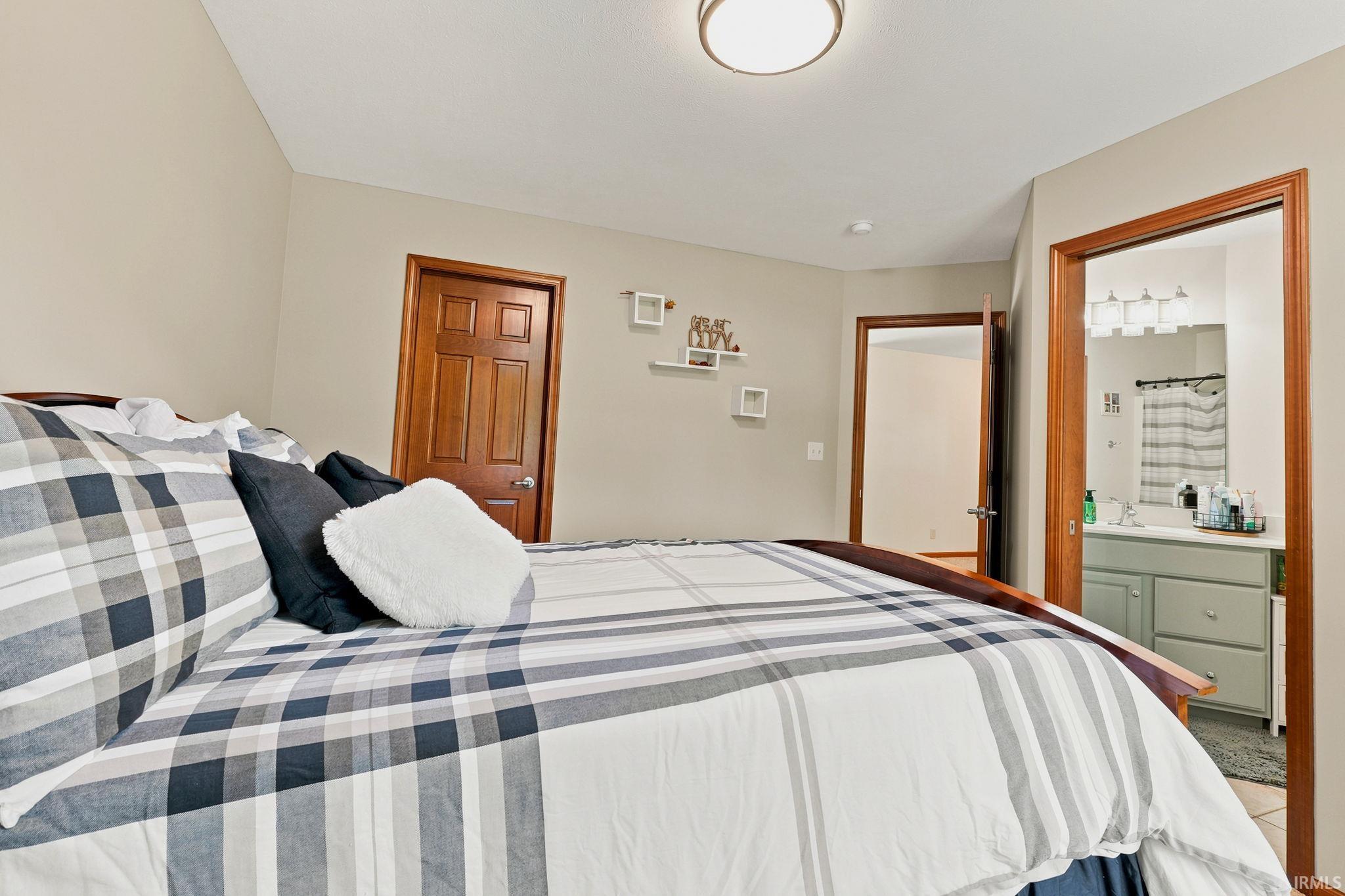 Spacious bedroom featuring neutral wall tones and wood-finish doors