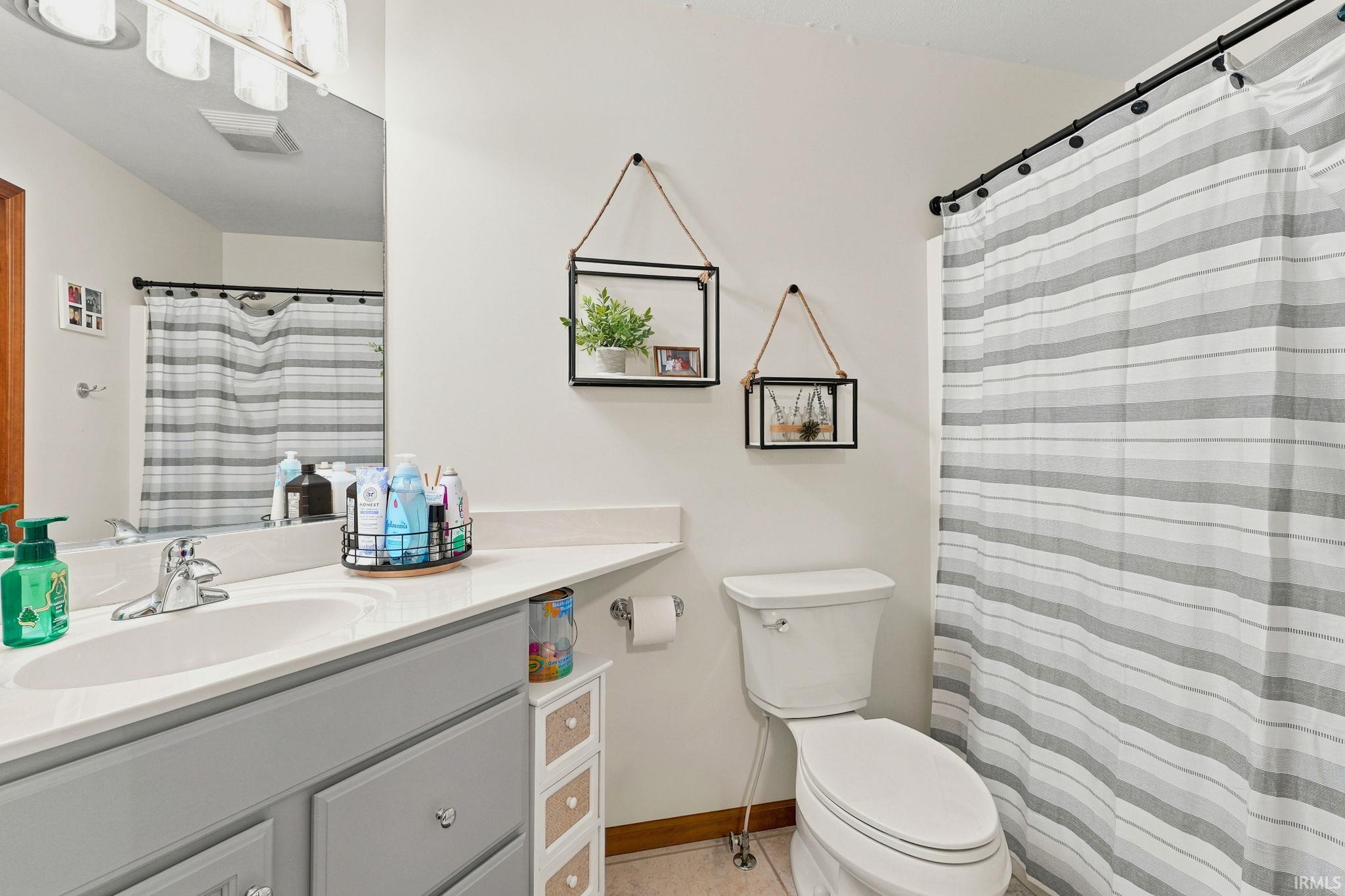 Bathroom featuring a vanity with an integrated sink, light-toned countertop, and gray cabinetry