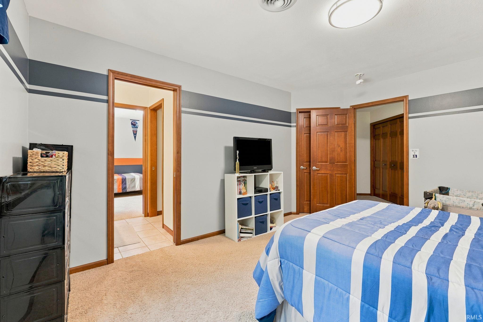 Carpeted room featuring a ceiling-mounted light fixture, recessed lighting, and wood-finish doors