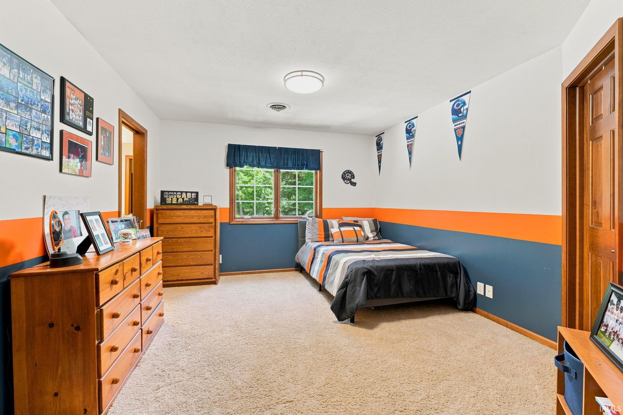 Carpeted room featuring a window with exterior views, painted walls, and wood-finish doors and trim